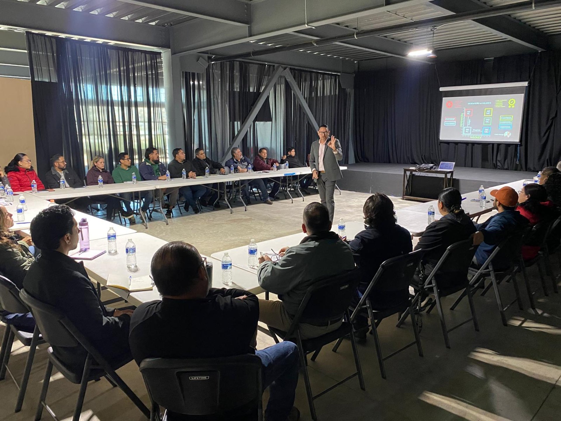 people sitting on chair in front of table while holding pens during daytime