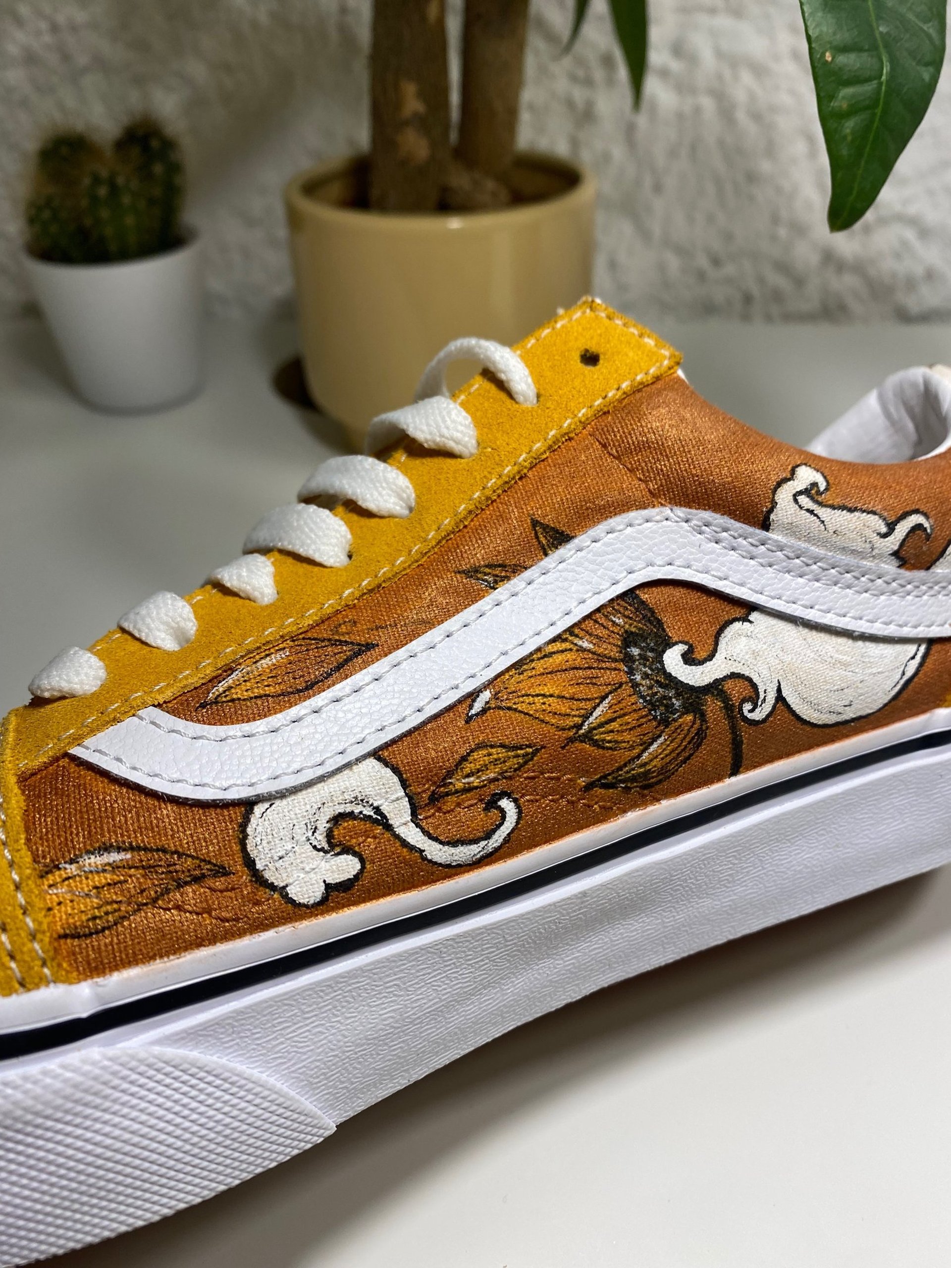 Orange custom vans shoe with a sunflower being blown off by the wind