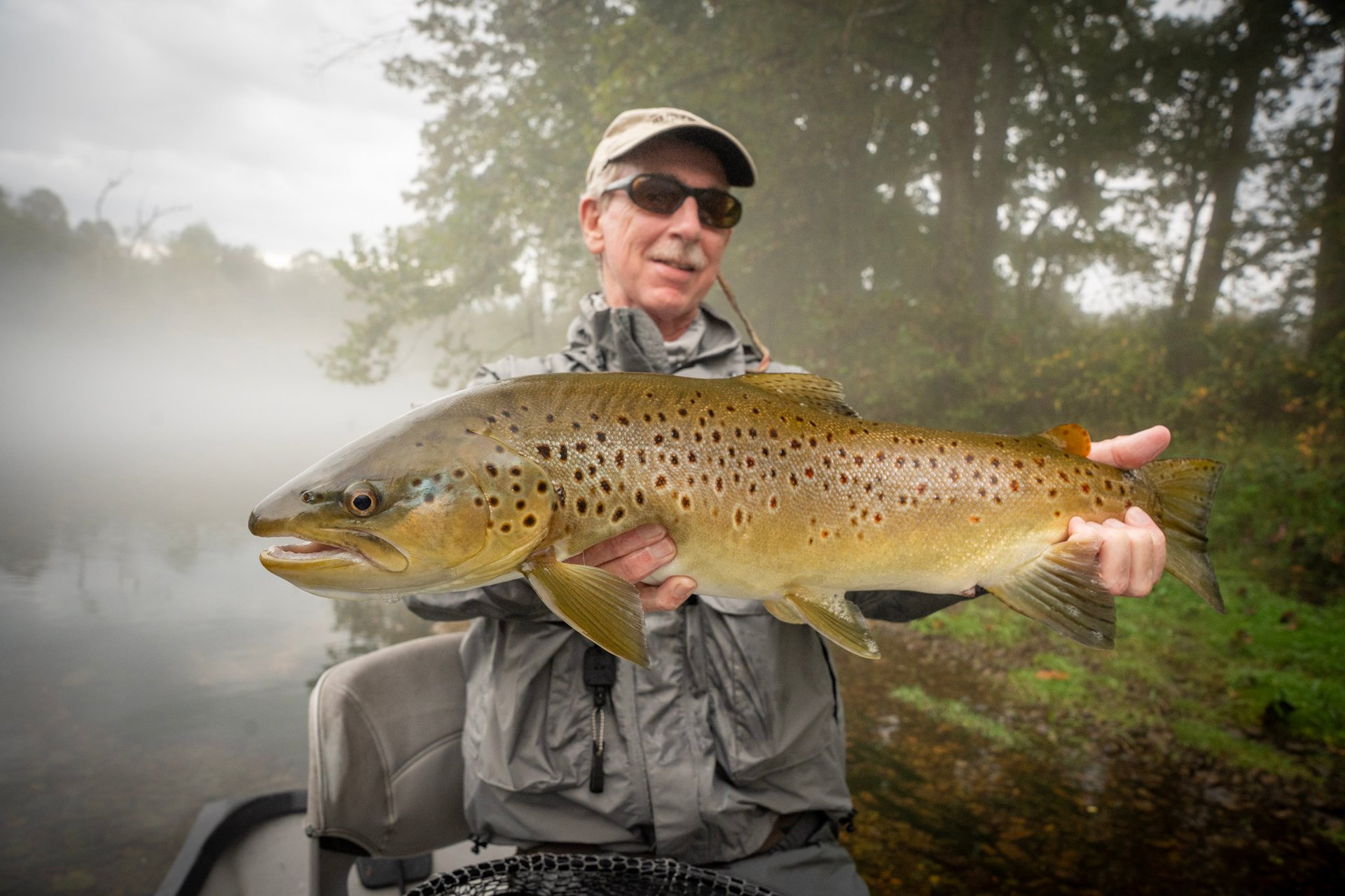 Head guide John Stunkard stands with Joe as they capture a new personal best brown trout.