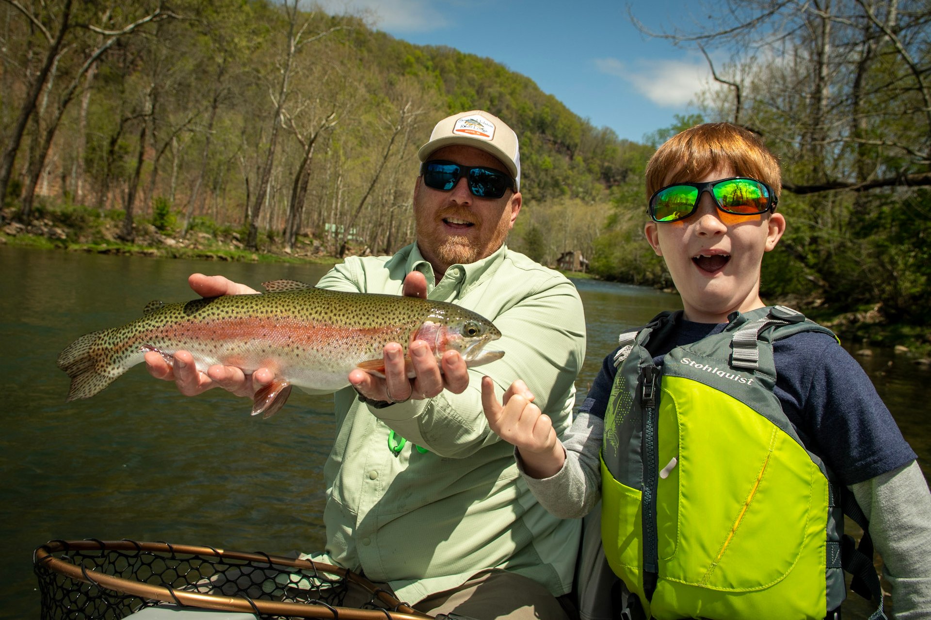 Father and son catch a big rainbow while floating the Watauga River.