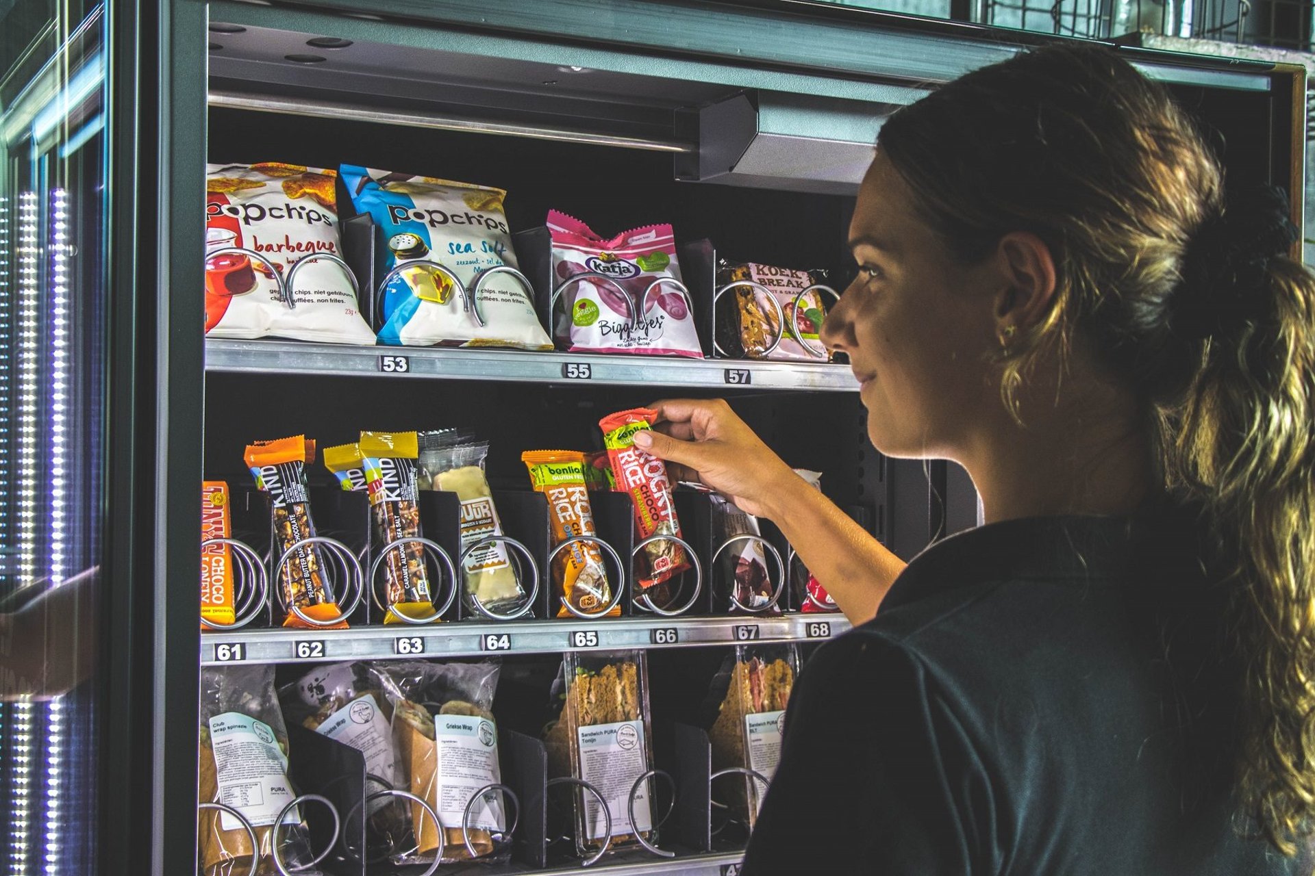A woman standing in front of a vending machine
