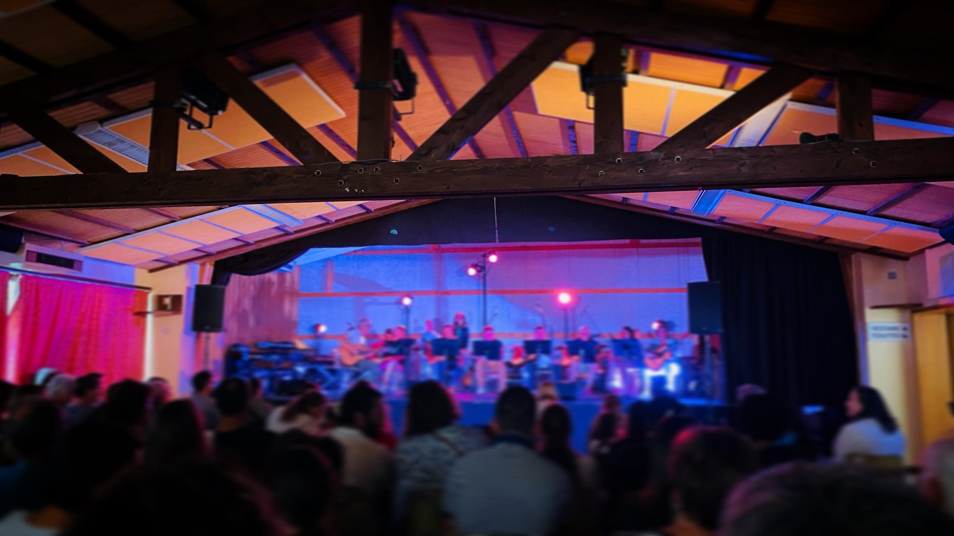 A red chair sitting in front of a microphone on top of a stage