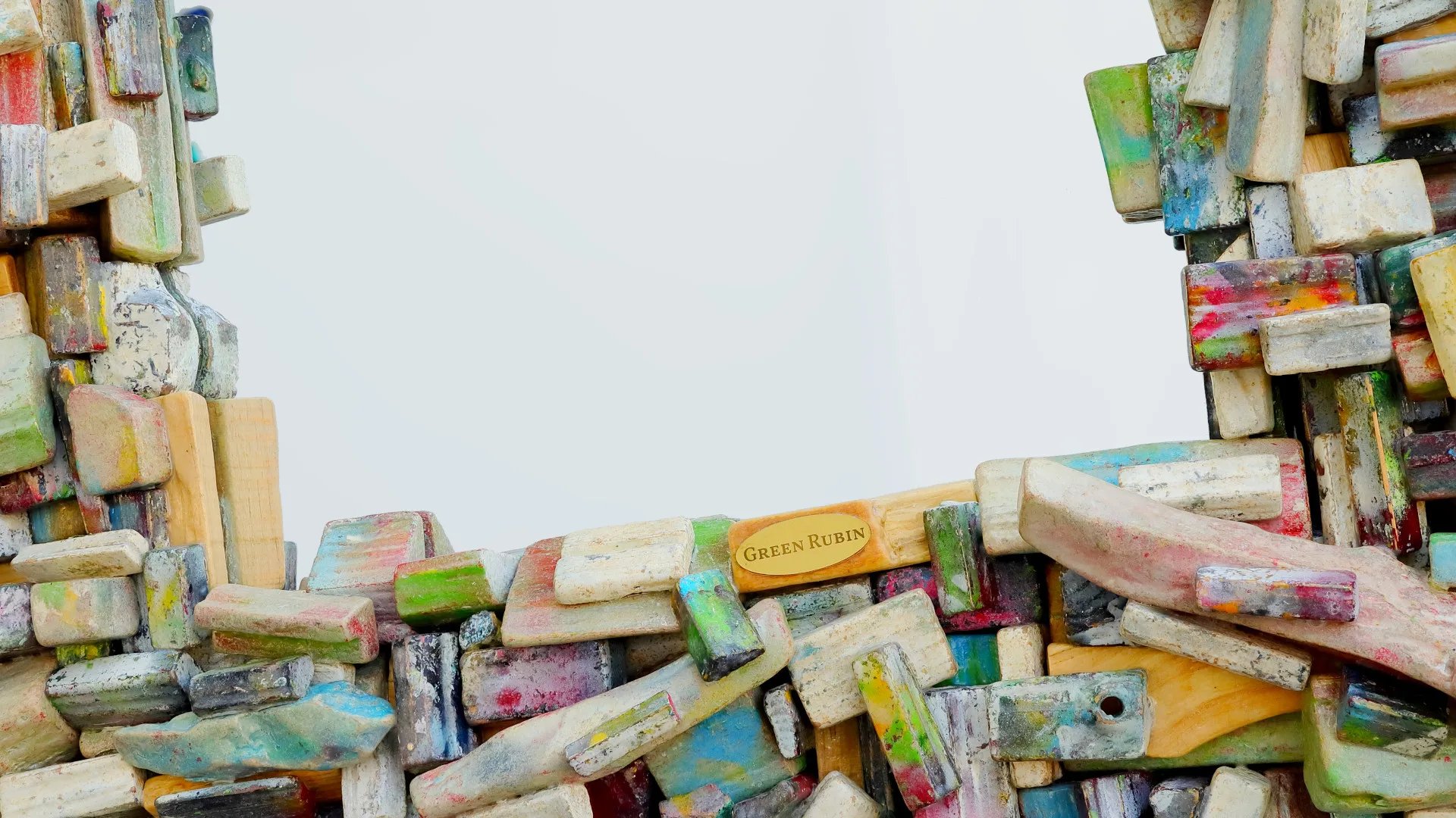 Untere Hälfte eines Spiegels mit kunstvollem Rahmen aus vielen kleinen, bunten Holzscheiten, mit Green Rubin Messing-Logo