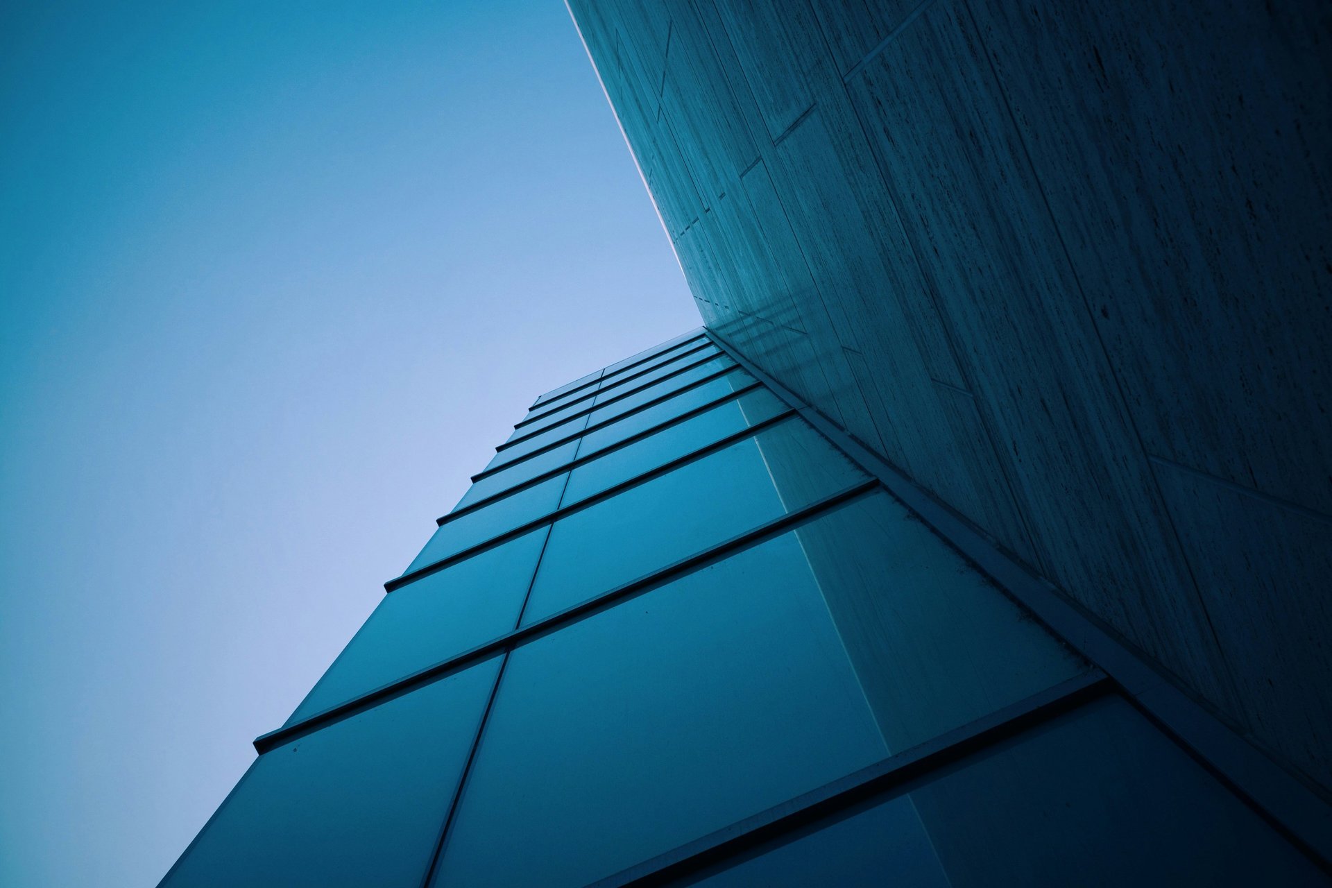 an abstract photo of a curved building with a blue sky in the background