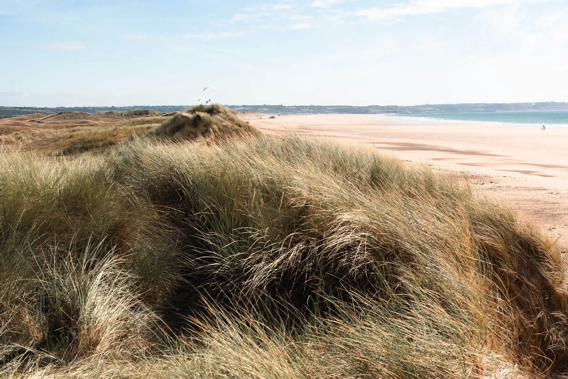 Paysage côtier de Normandie avec falaises emblématiques et mer bleue, idéal pour un road-trip familial en Europe. Photo de vo