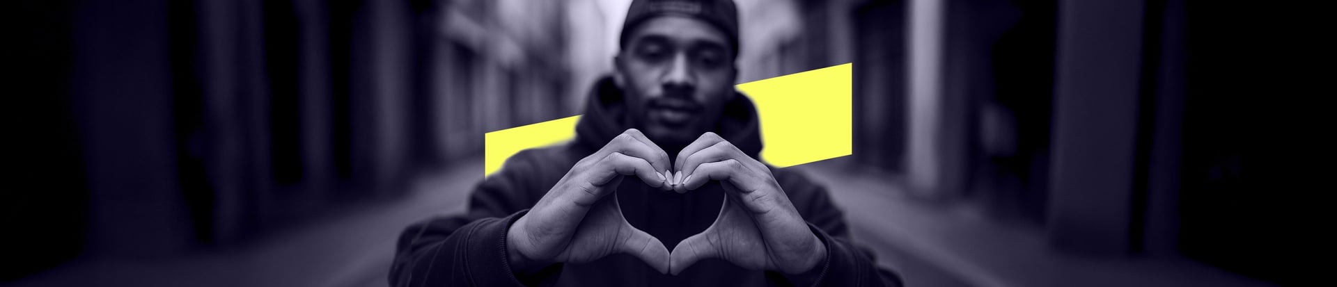 Wide banner image of man making heart symbol with hands