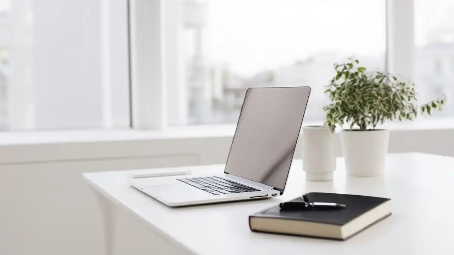 Moderner Arbeitsplatz mit Laptop und Notizbuch