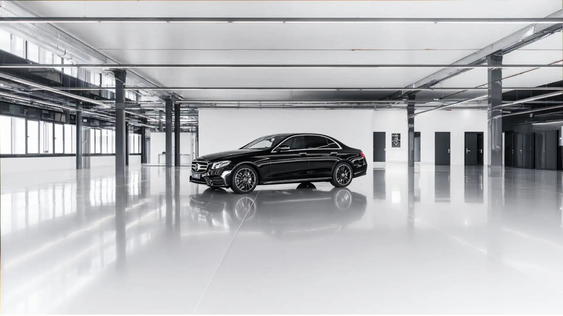 Moderne Kfz-Prüfhalle mit schwarzer Oberklasse-Limousine