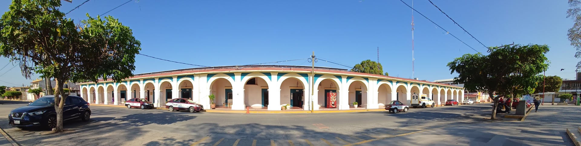 a large building with a dome and a courtyard with people walking around
