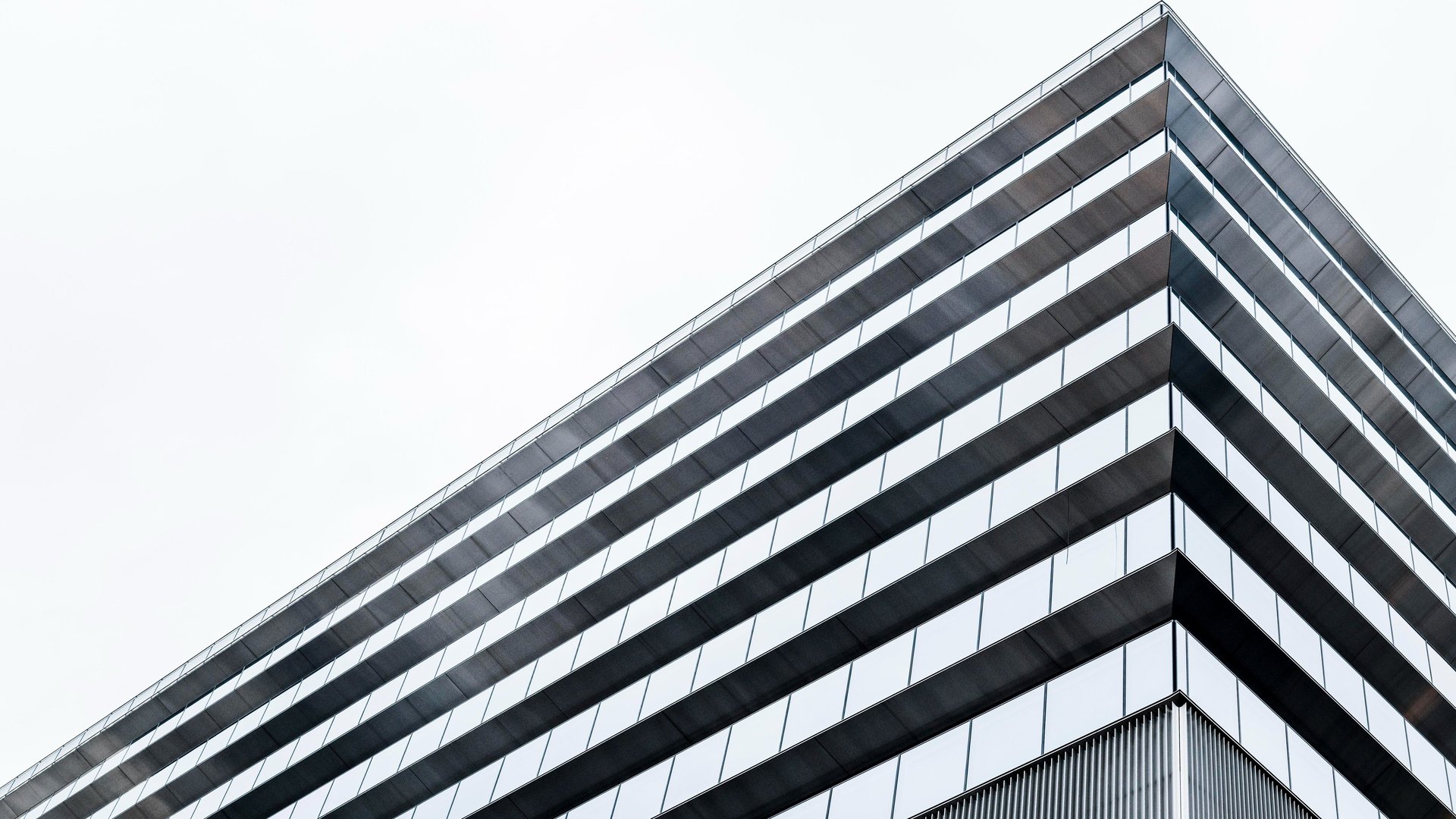 an abstract photo of a curved building with a blue sky in the background