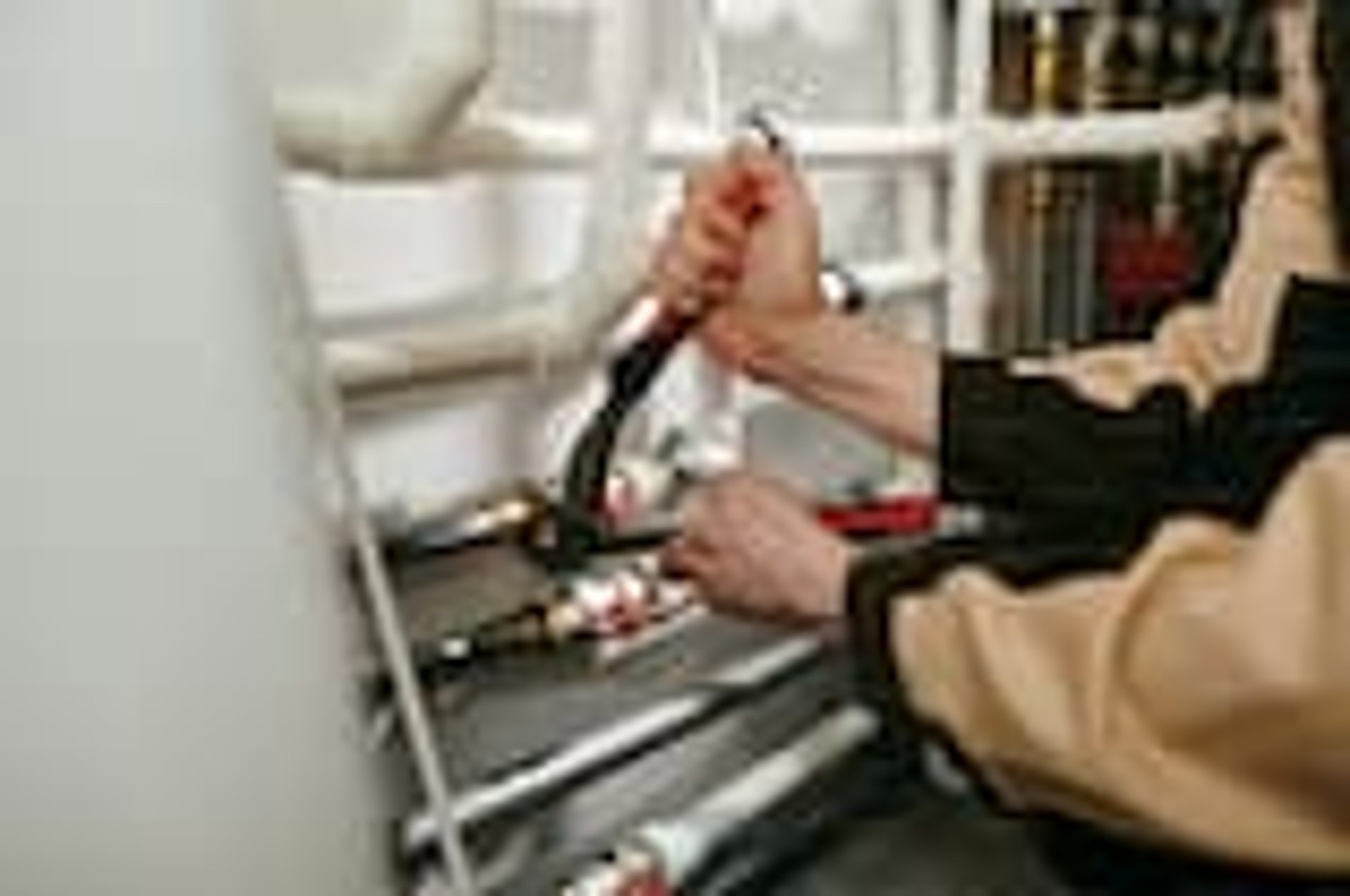 A plumber repairs plumbing in a bathroom.