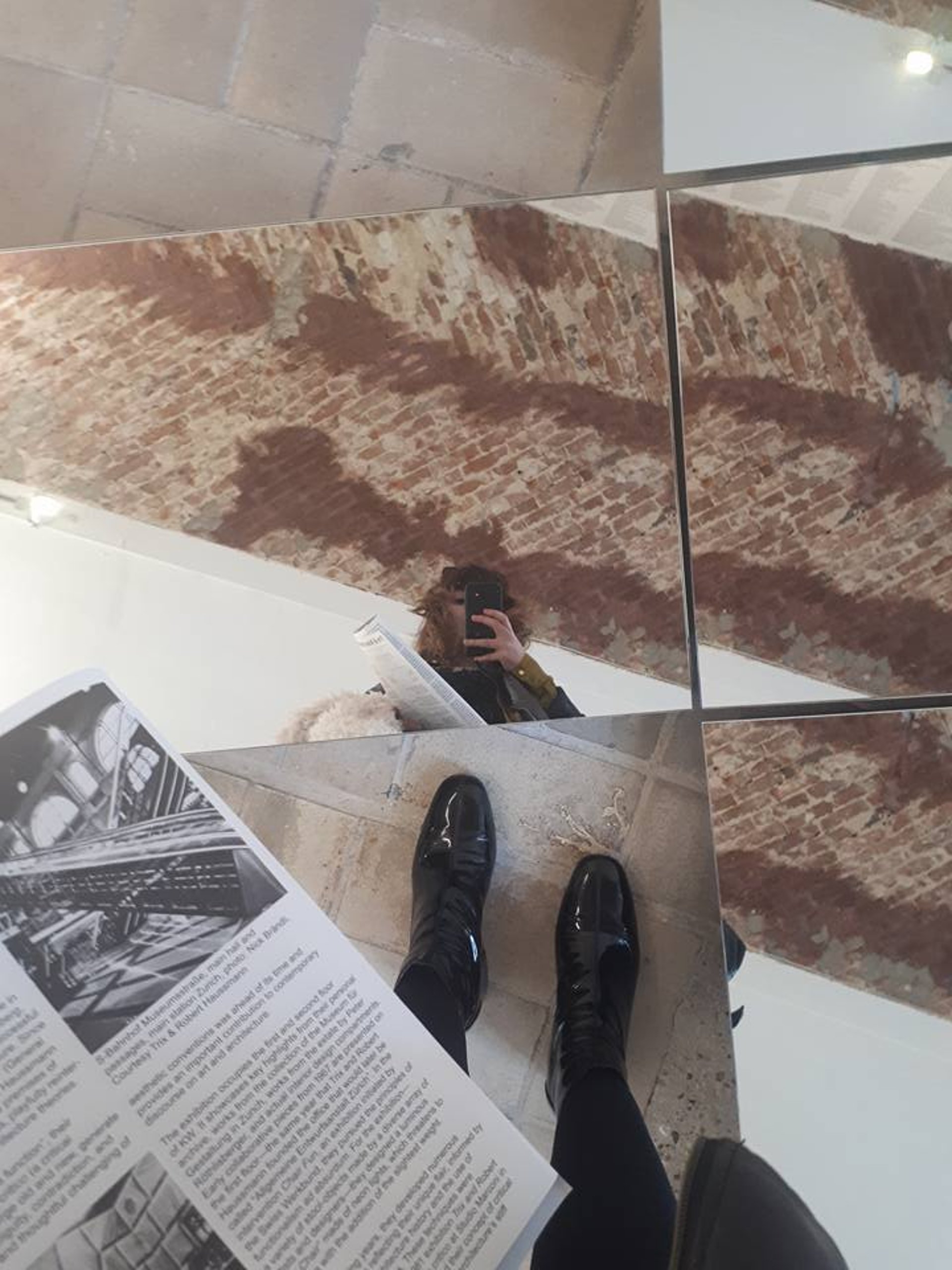 Reflection of Tina Bikic holding a book in a mirror installation, representing PDS as a scientific and artistic research meth