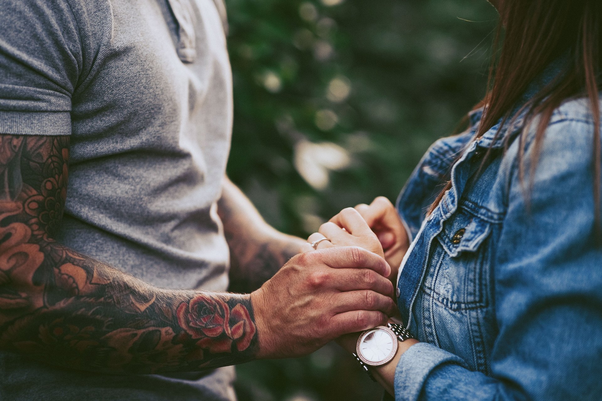 Dettaglio delle mani di lui che stringono dolcemente le mani di lei durante una sessione fotografica prewedding