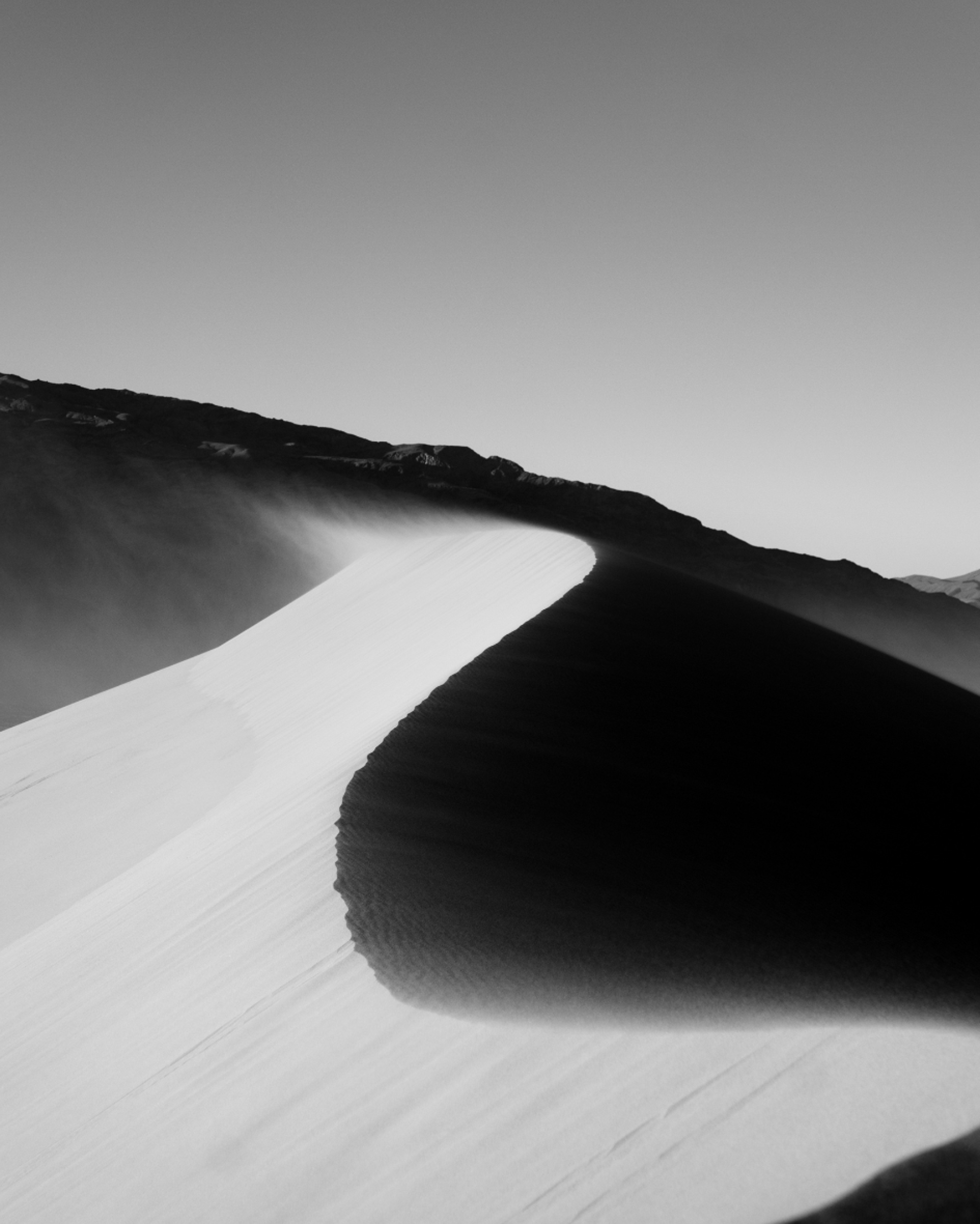 an abstract photo of a curved building with a blue sky in the background