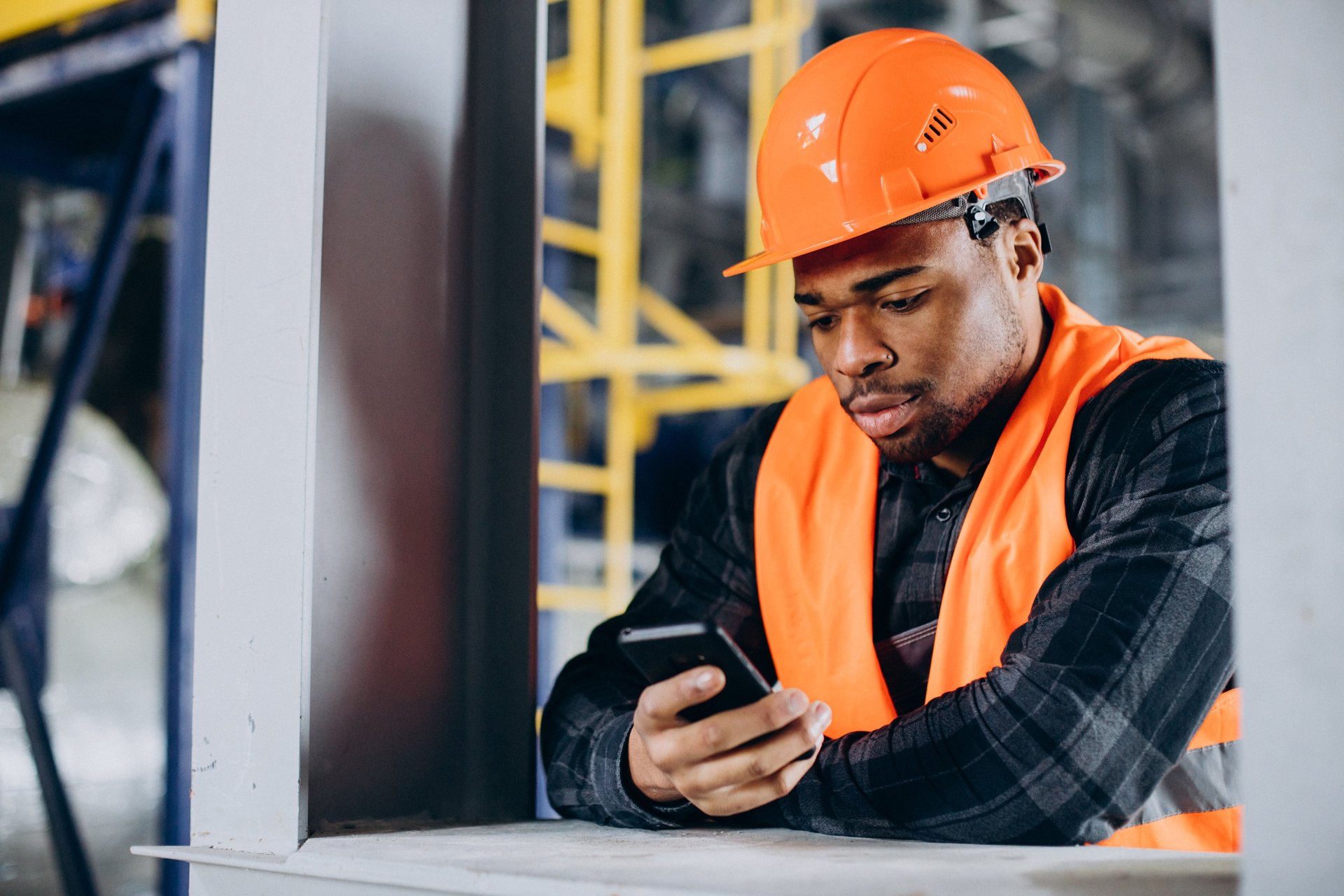 A male tradseperson on their phone after a job 