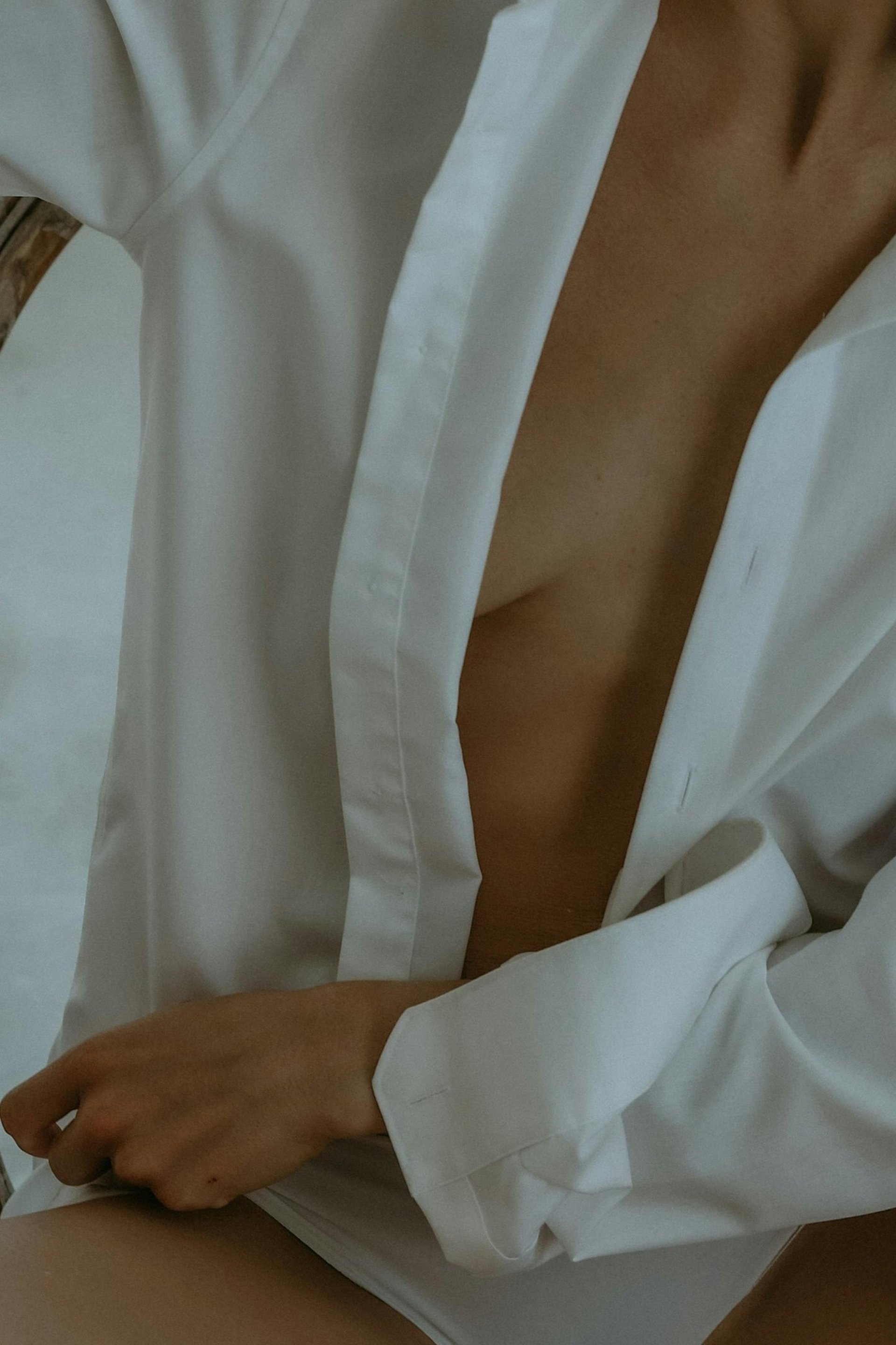 topless person standing near white petaled flowers