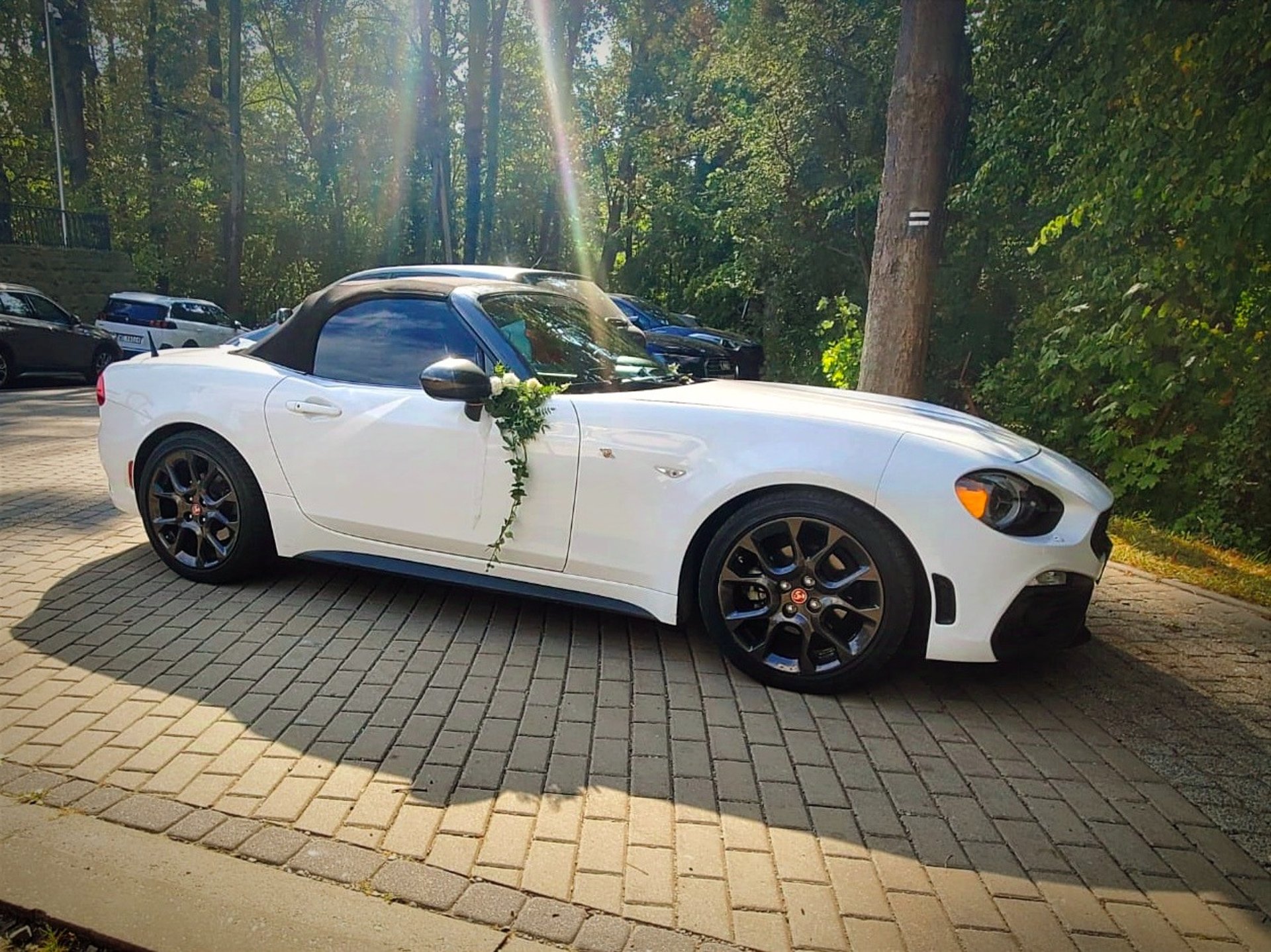 a white convertible car on a road