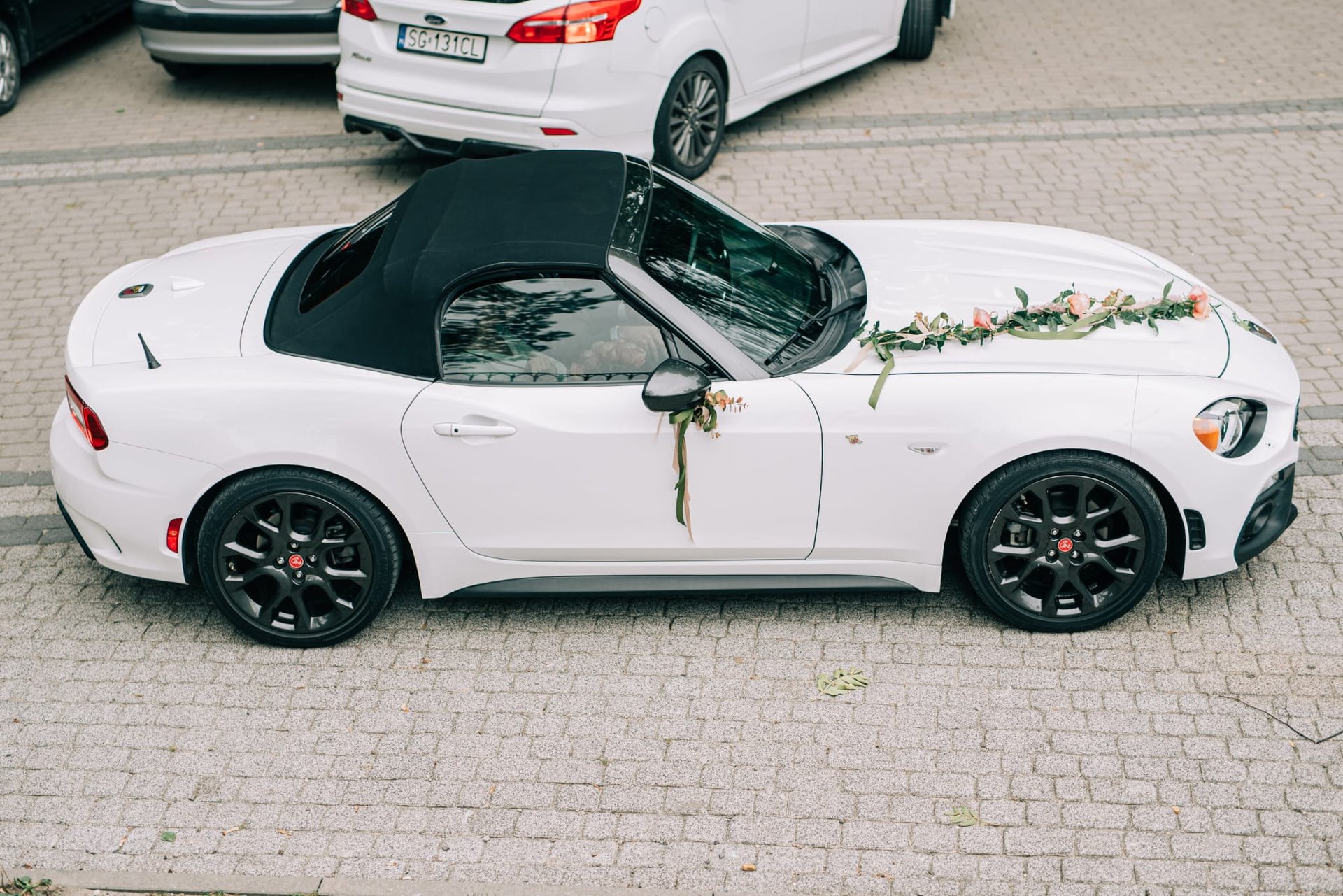 a white convertible car on a road