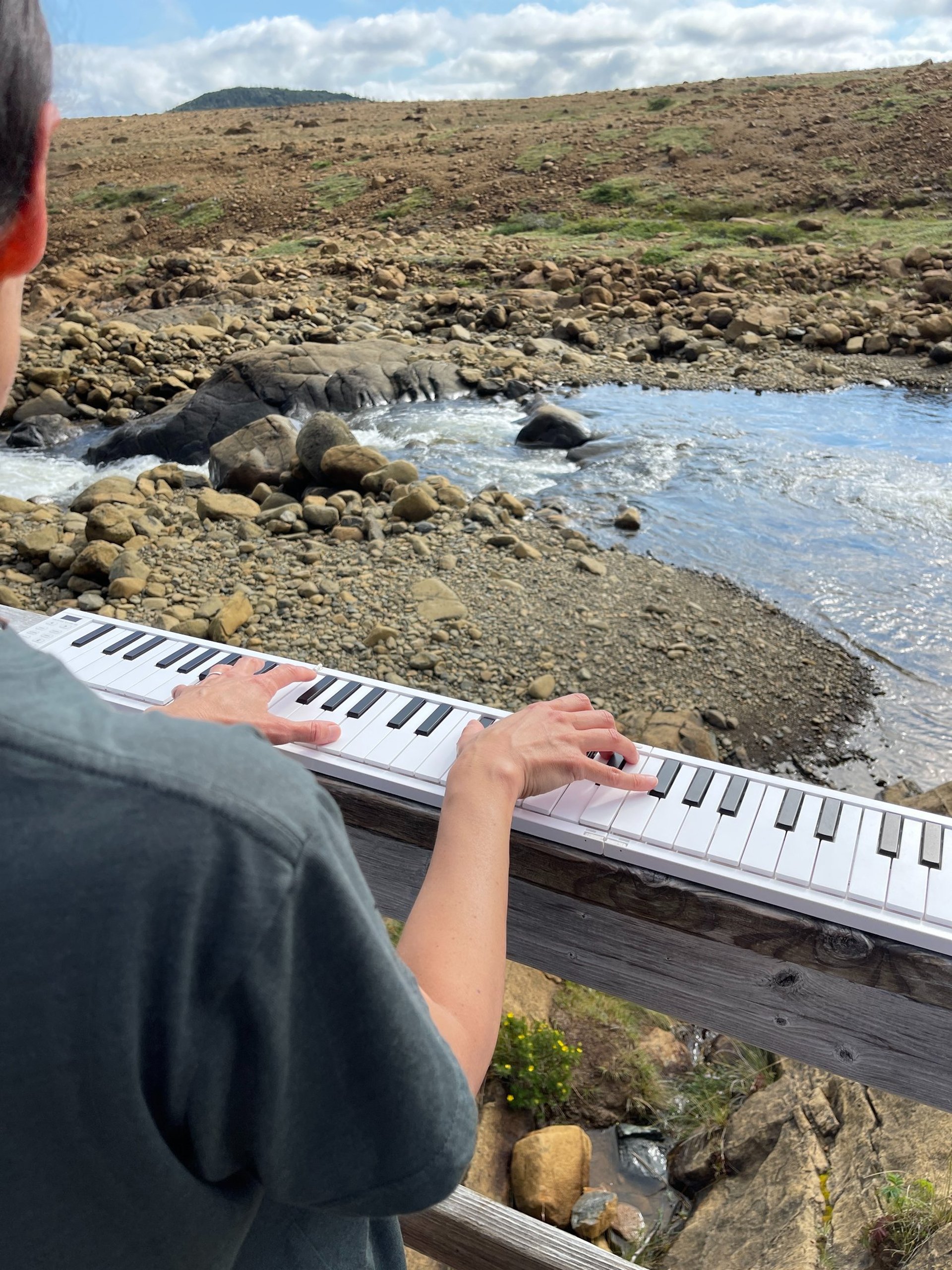 photo of composer Jen Smith Lanthier playing a travel keyboard in Newfoundland