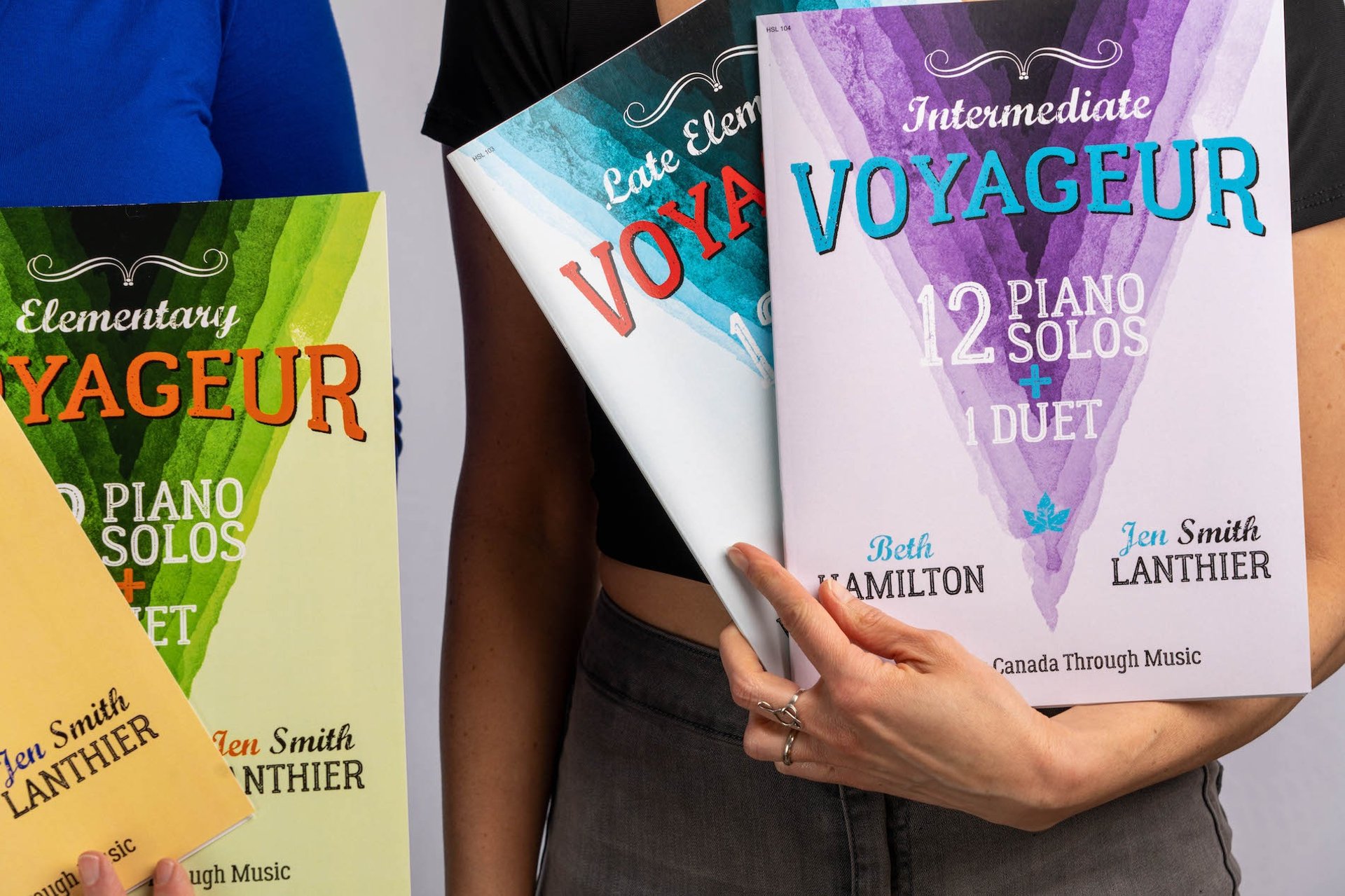 Yellow, green, blue and purple Voyageur piano books