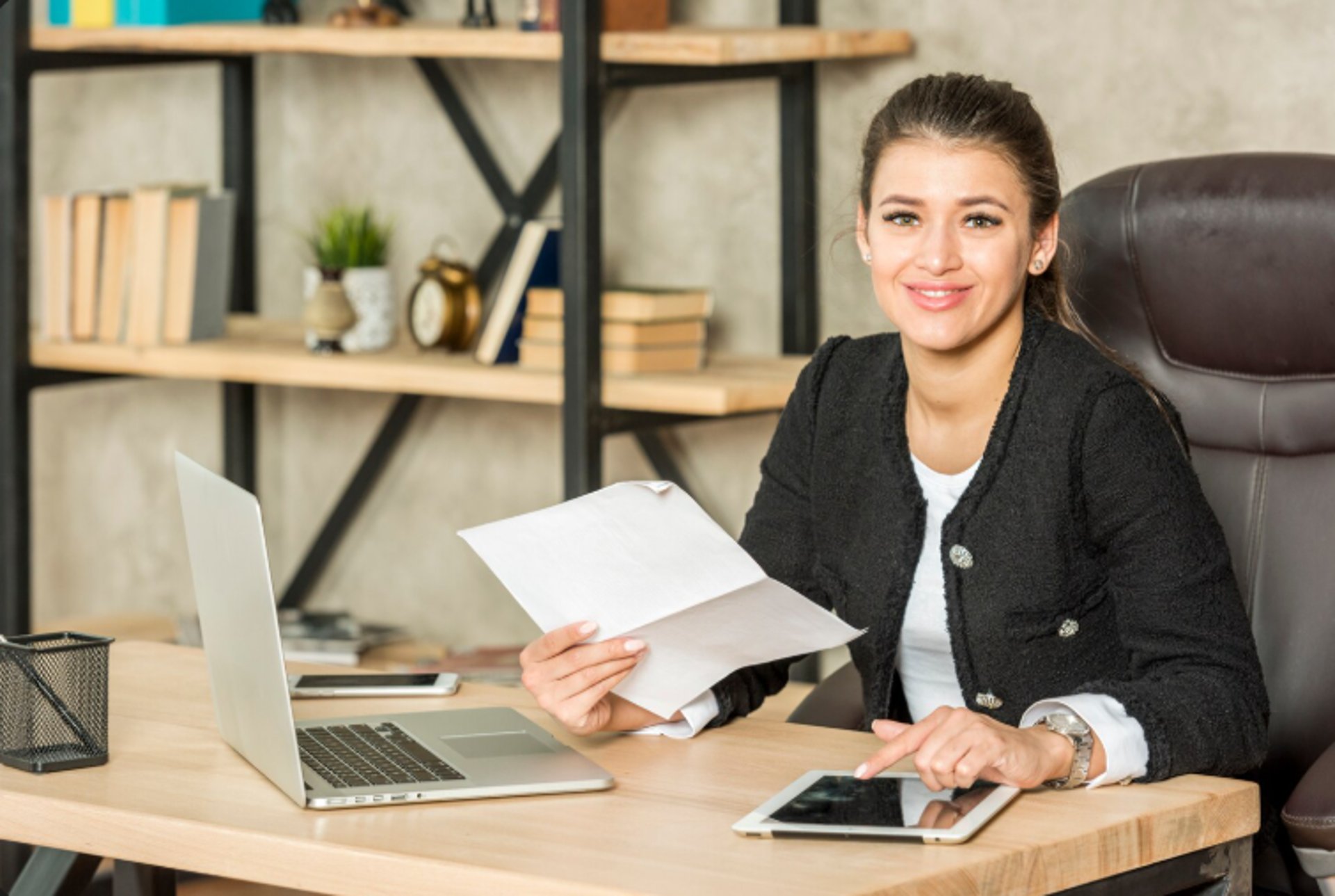woman in brown long sleeve shirt sitting by the table using macbook