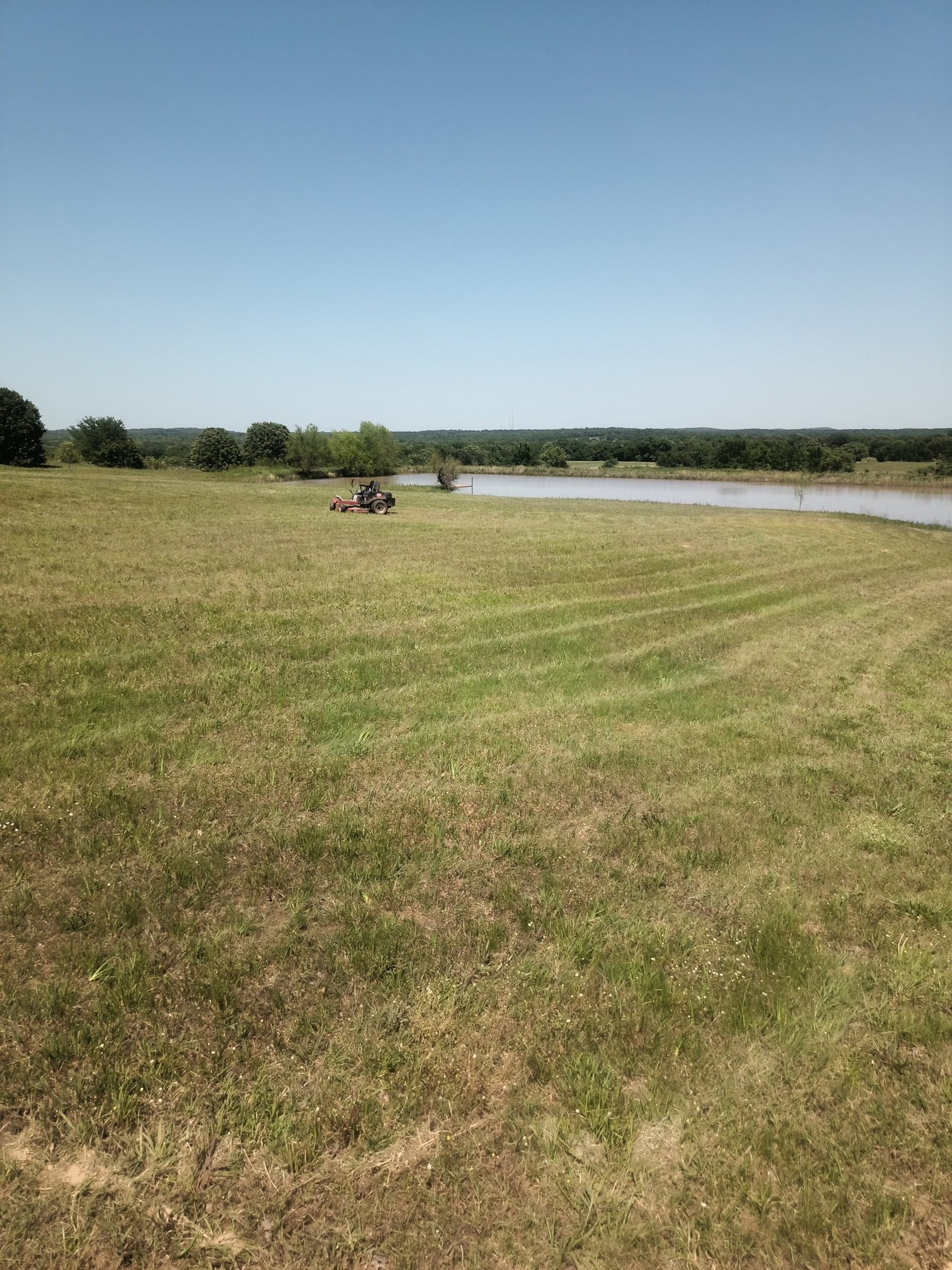 a green lawn mower sitting on top of a lush green field