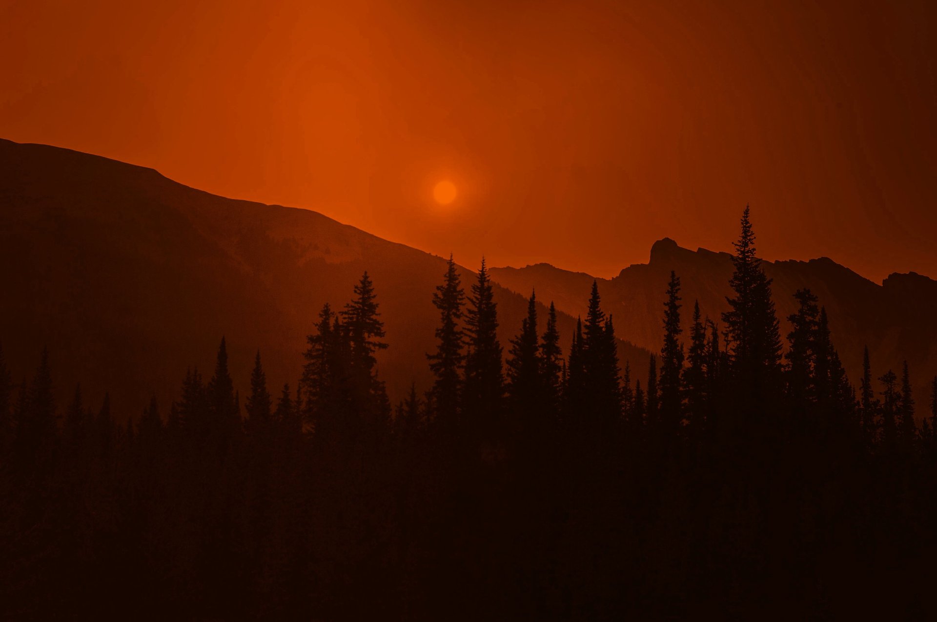 the sun is setting behind a mountain side