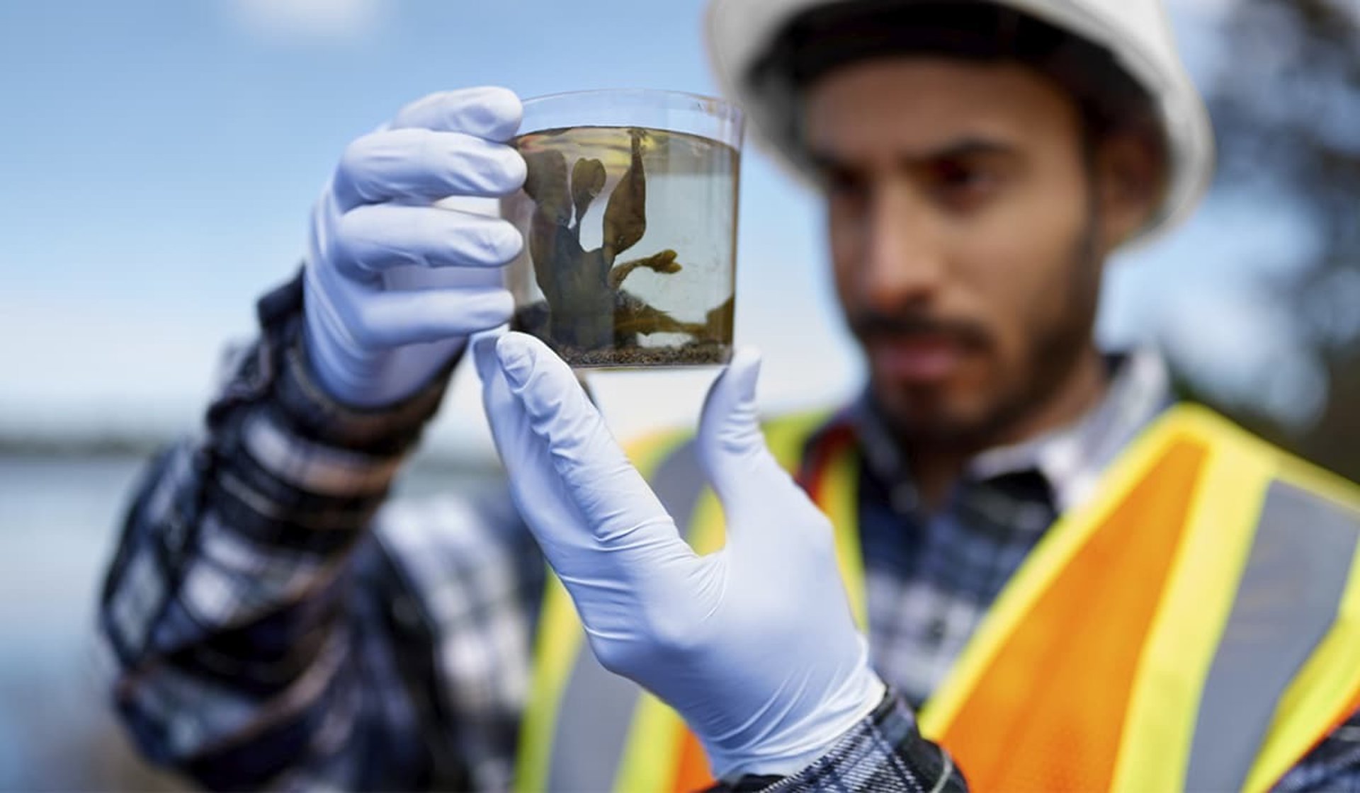 three men laughing while looking in the laptop inside room