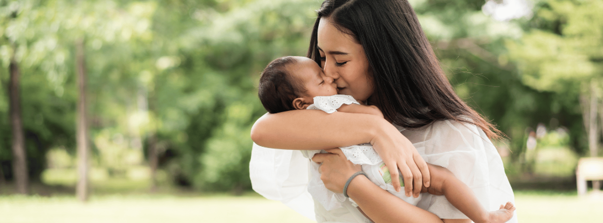 woman carrying smiling baby