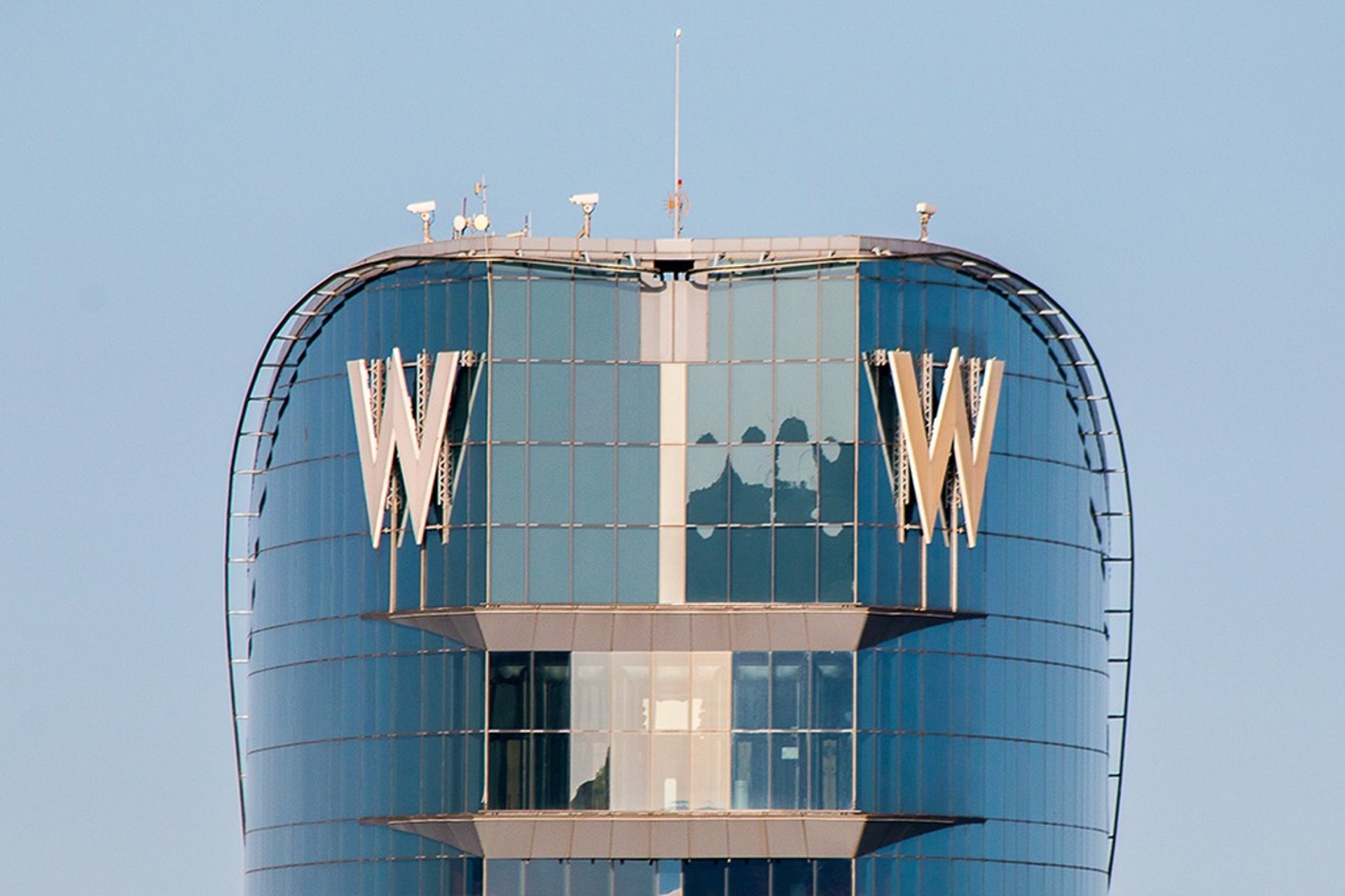 an abstract photo of a curved building with a blue sky in the background