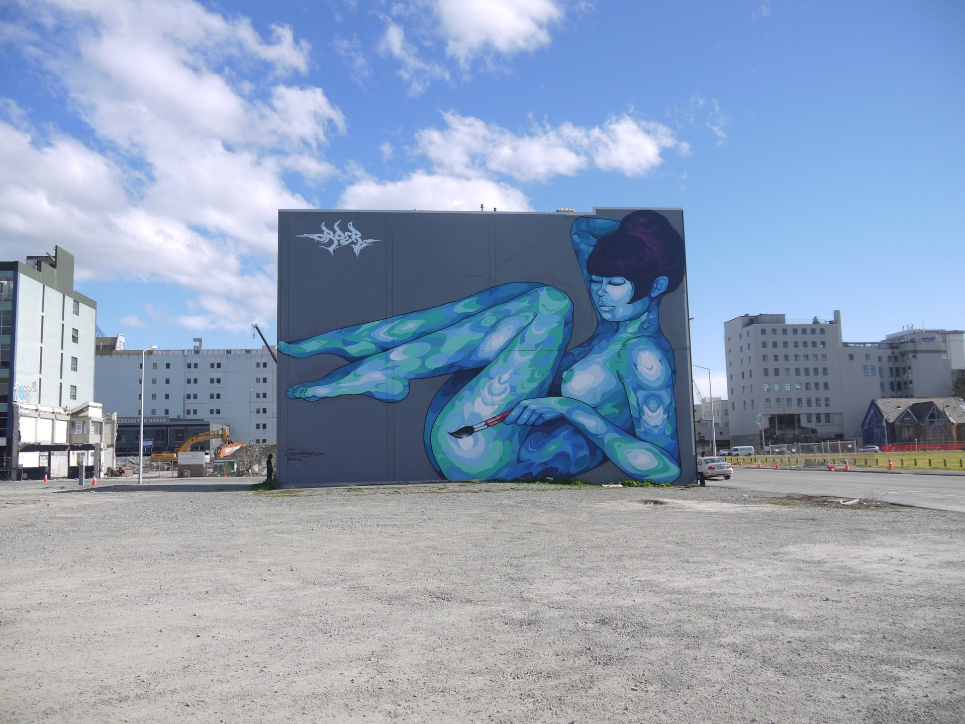 woman painting street art mural
