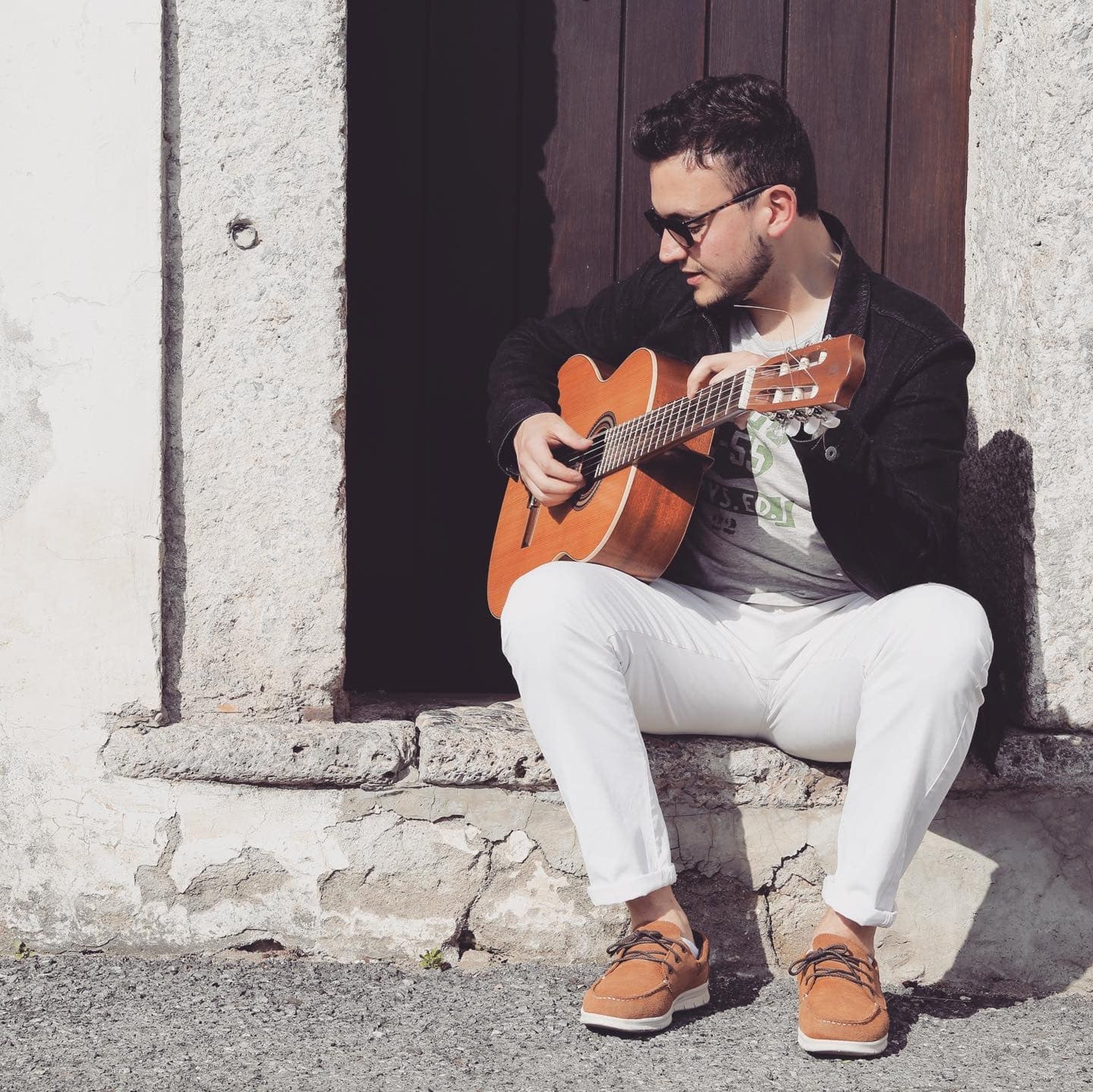 man playing acoustic guitar selective focus photography