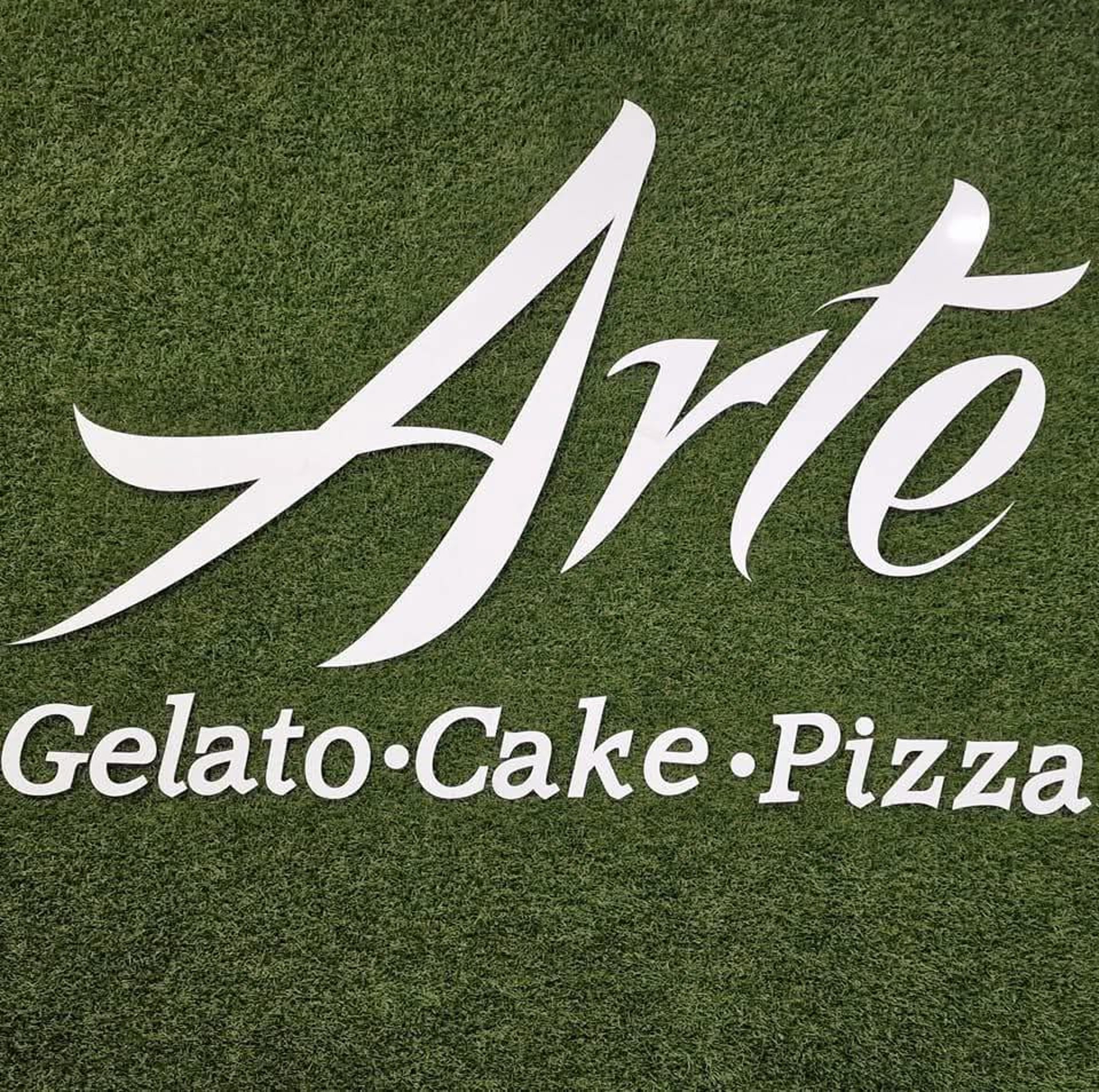 A green dessert with white flower topping on plate.