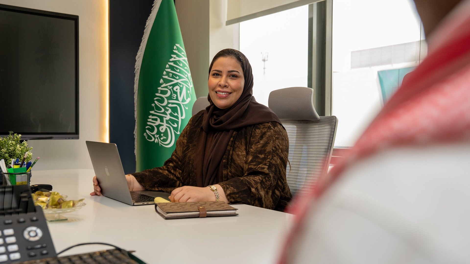 MacBook Pro, white ceramic mug,and black smartphone on table