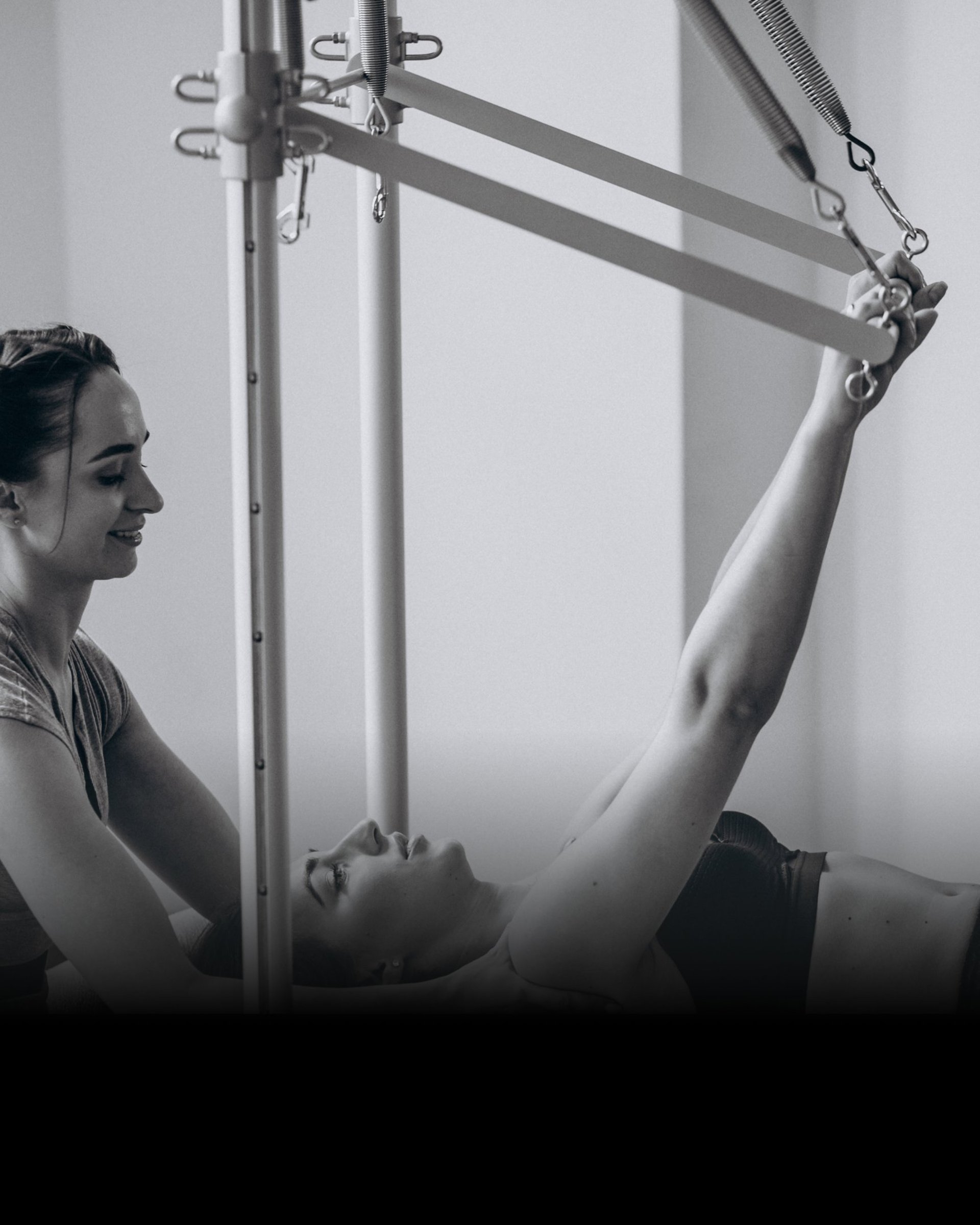 woman in black long sleeve shirt and blue denim jeans sitting on white concrete wall