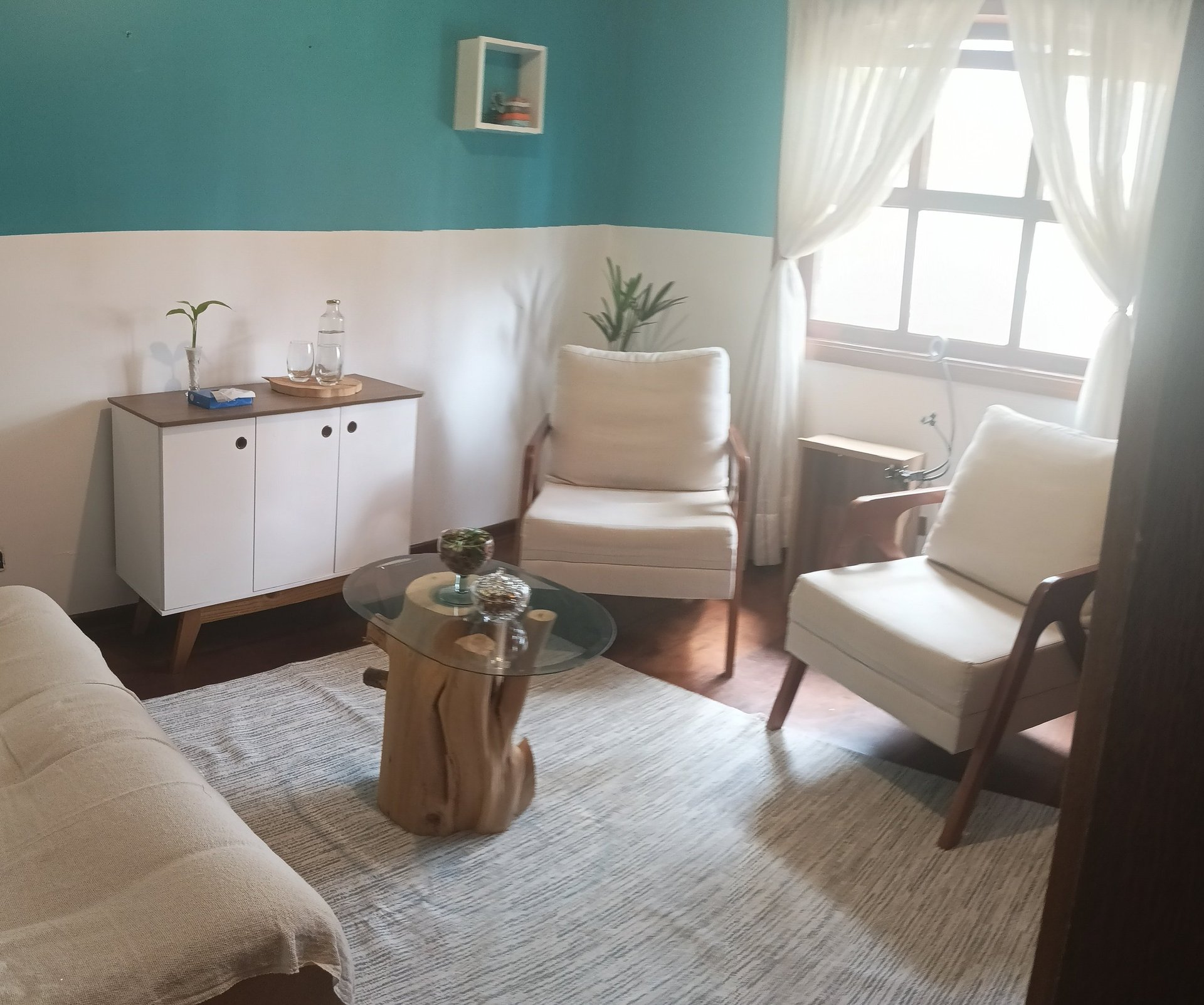 a living room with two chairs and a plant