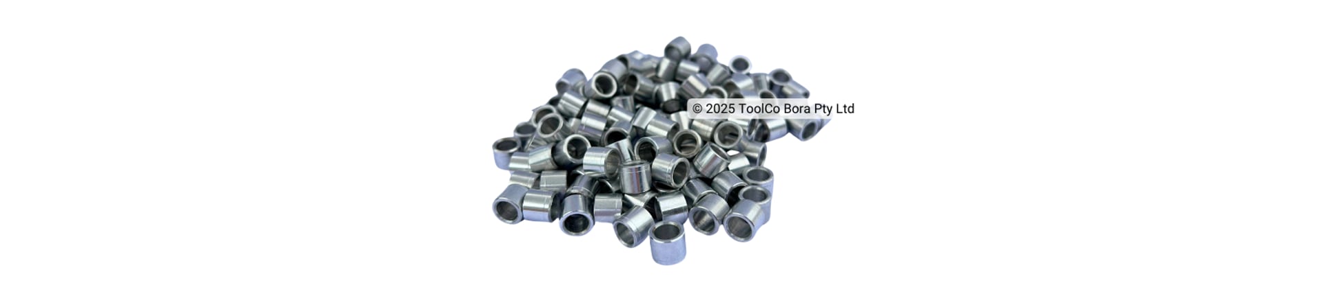 A pile of small aluminium CNC machined parts on a white background