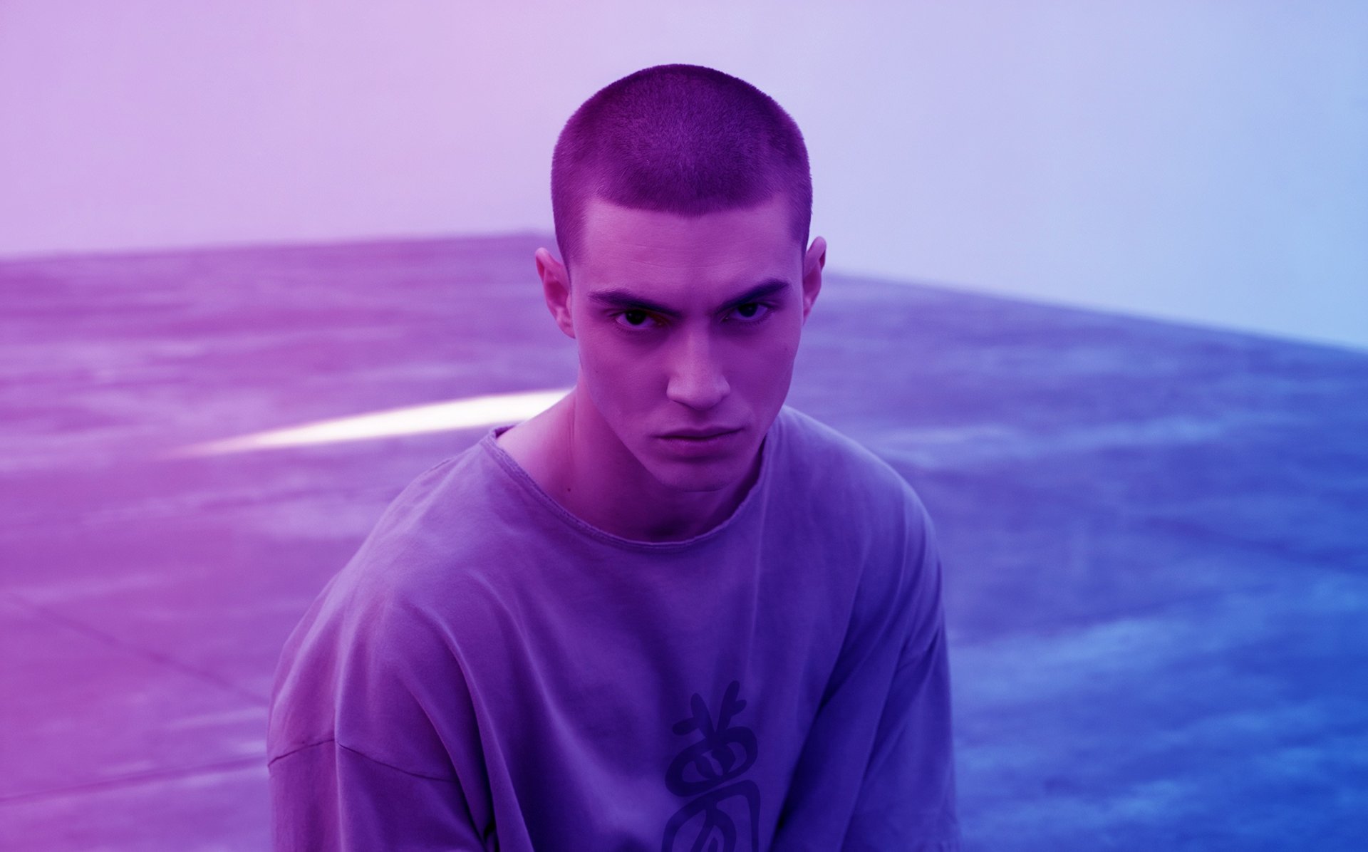 man model wearing Fulutee white T-shirt with Fu talisman Dream Seeker design in an empty room