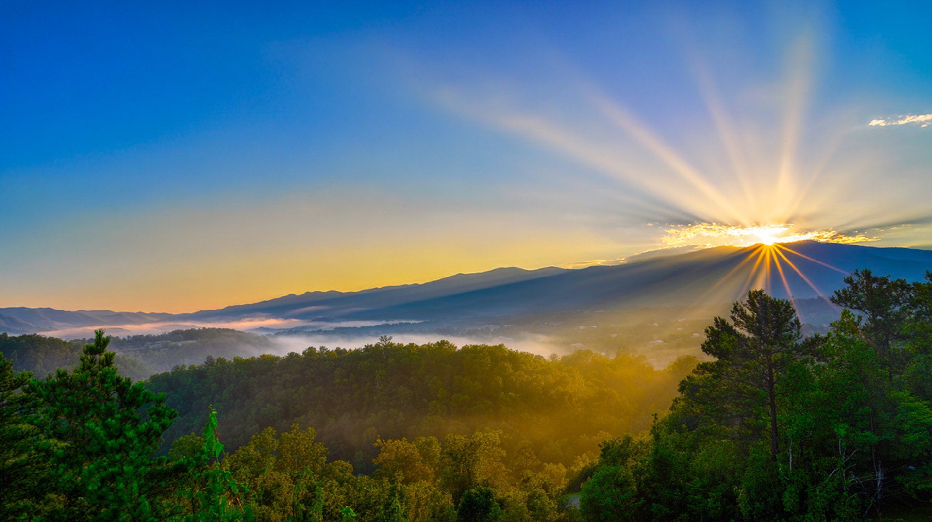 silhouette of mountain under white and yellow sky