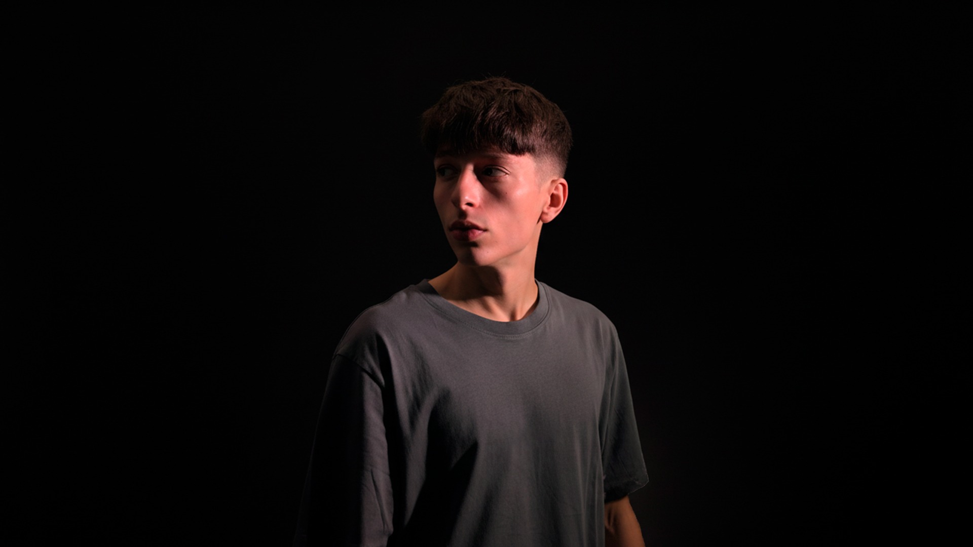 selective focus silhouette photography of man playing red-lighted DJ terminal