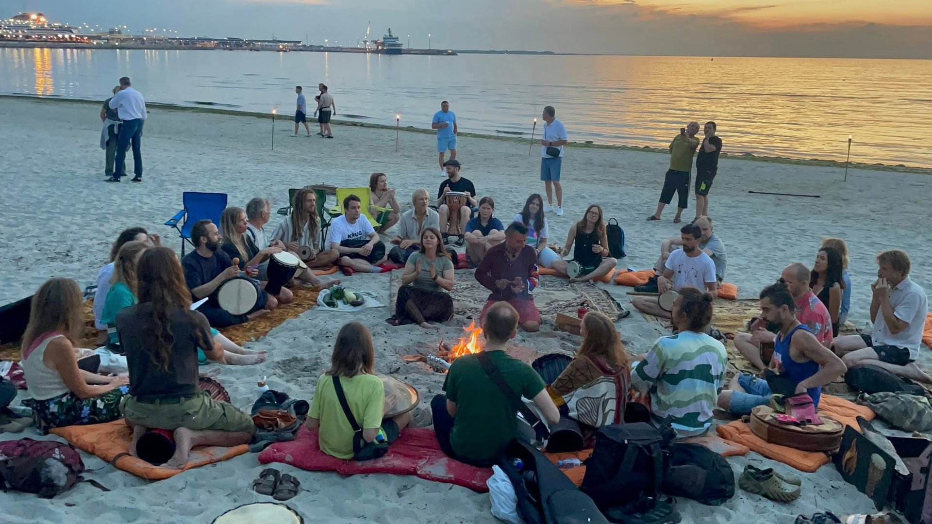 People singing and drumming at the beach, sunset time.  Photo by Eri Ka (drumming circle member)