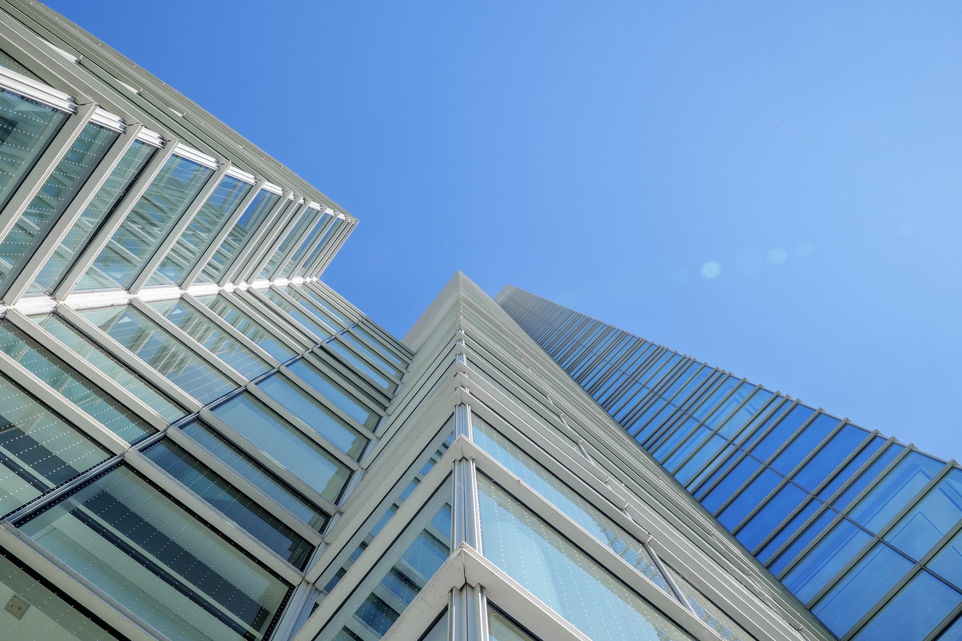 an abstract photo of a curved building with a blue sky in the background