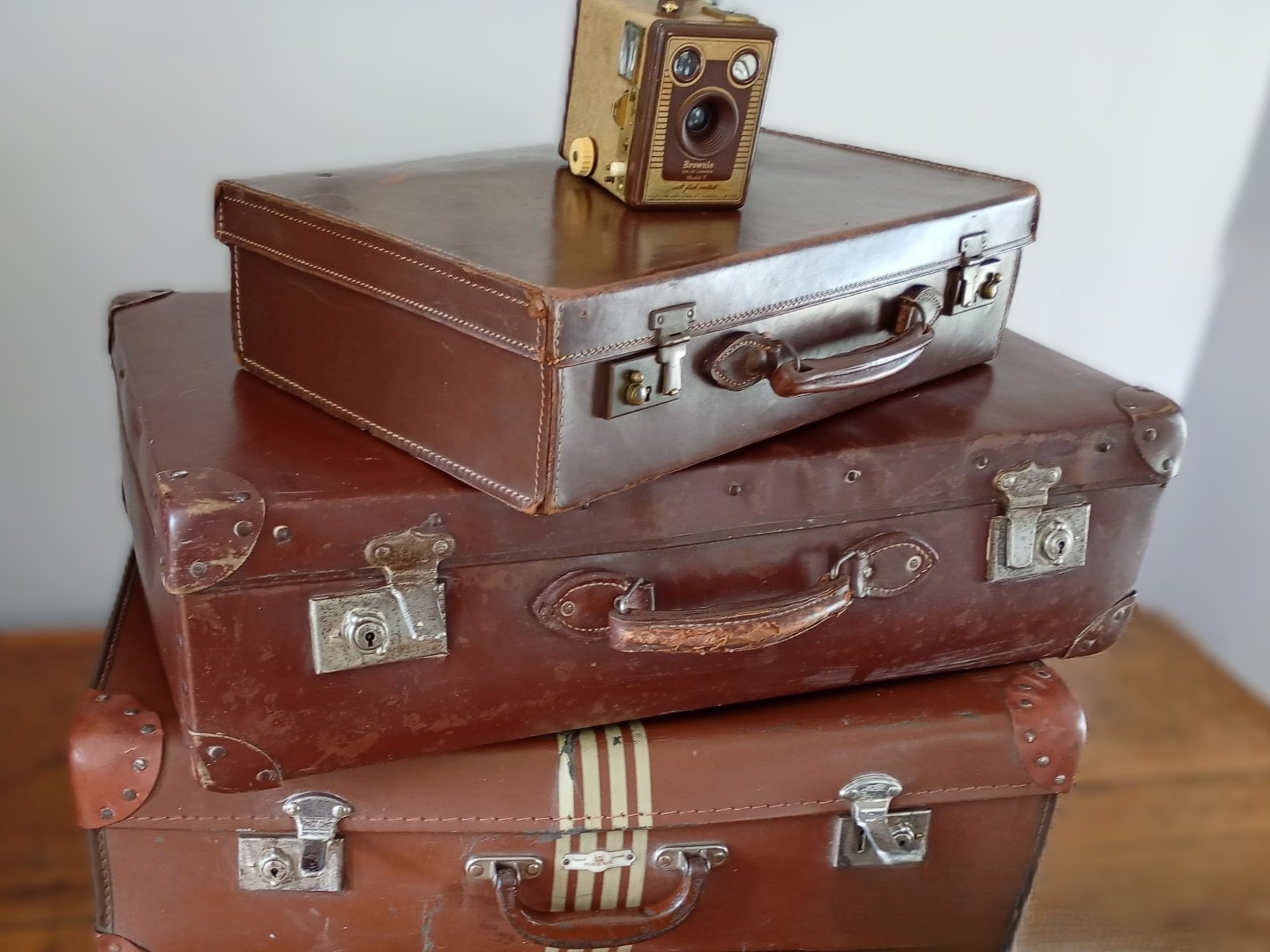 Three vintage suitcases and a box brownie camera