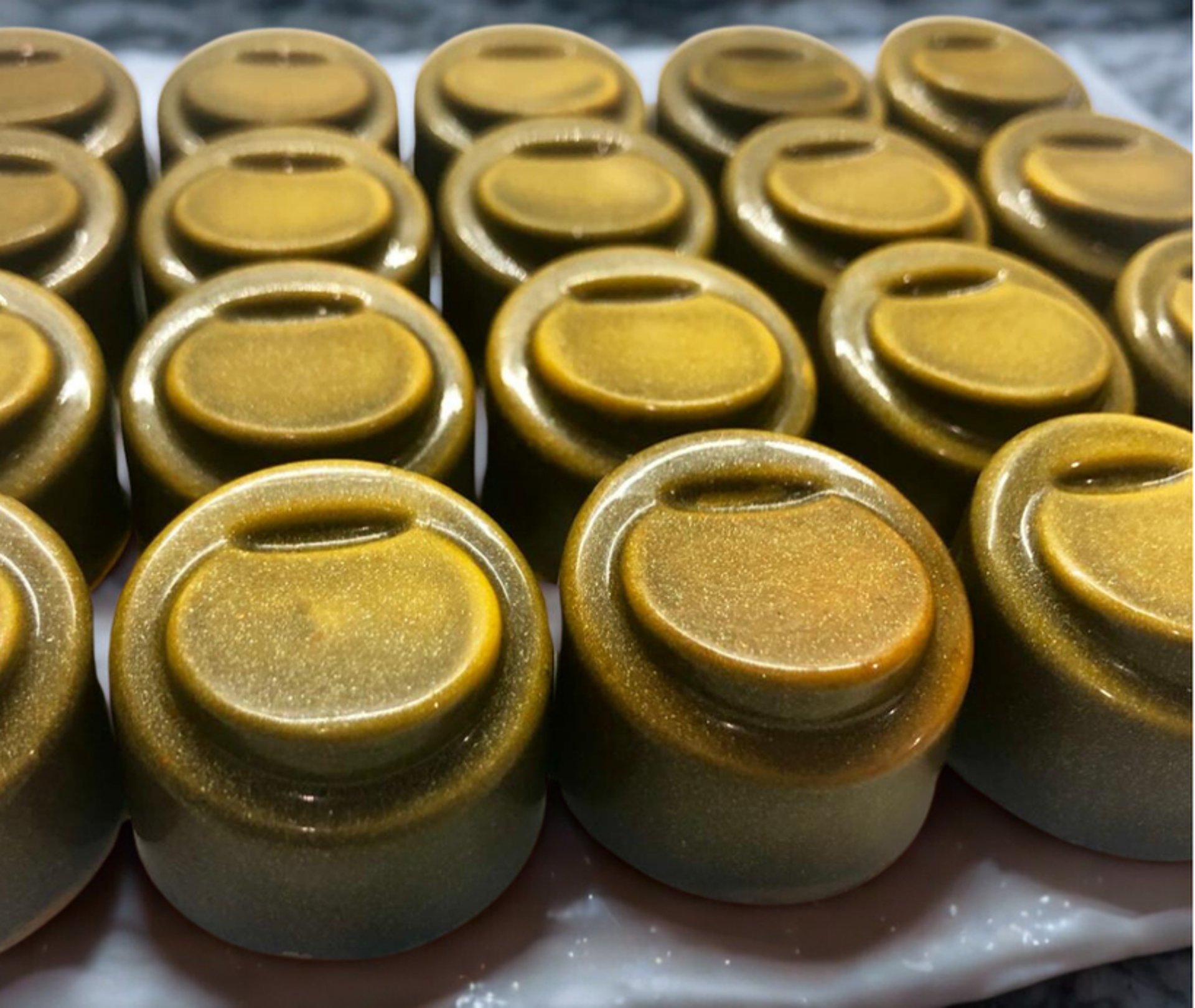 Shiny chocolate bonbons, colorful cocoa butter designs and rich ganache fillings, handcrafted for elegant and indulgent treat