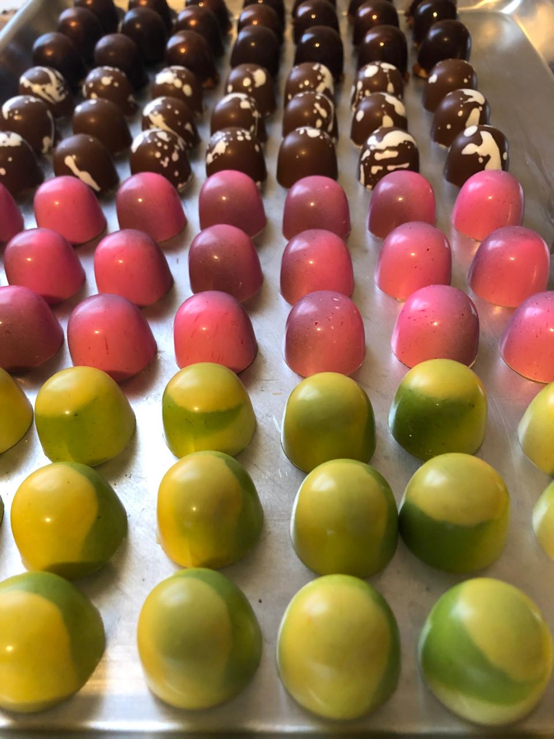 Assorted flavored chocolates in various vibrant colors, showcasing a variety of rich tastes and artisanal craftsmanship.