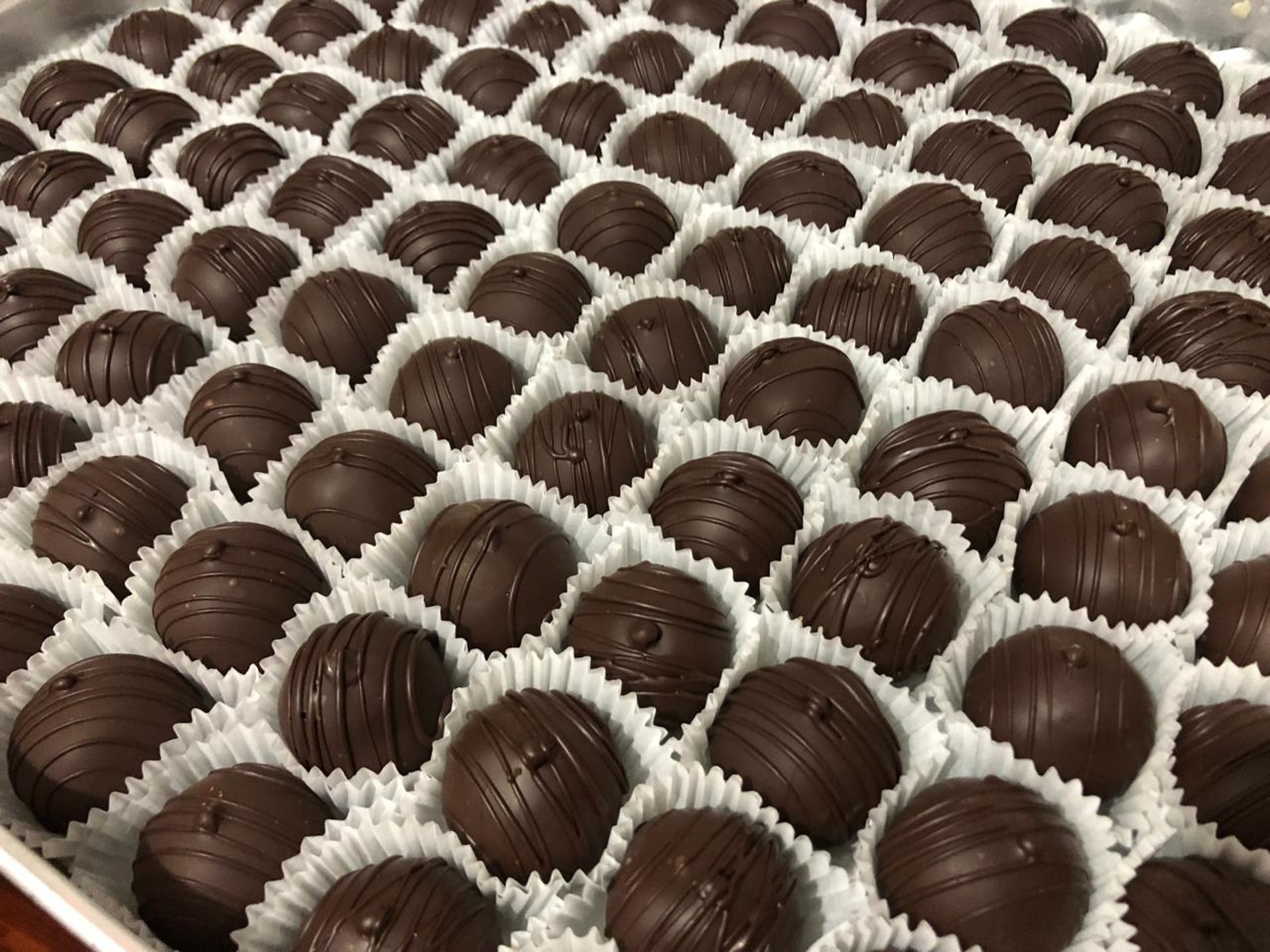 Elegant, soft, and delicious truffles handcrafted by Natalia at Chocos Cookies Cakes, showcasing gourmet chocolate artistry.