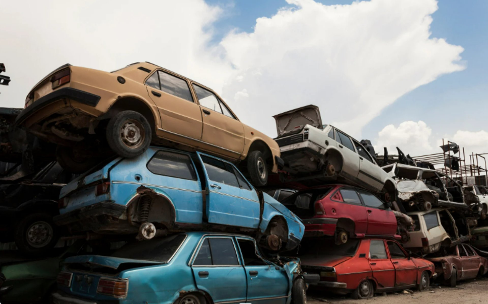 A row of stacked scrap cars in a Burnaby yard.