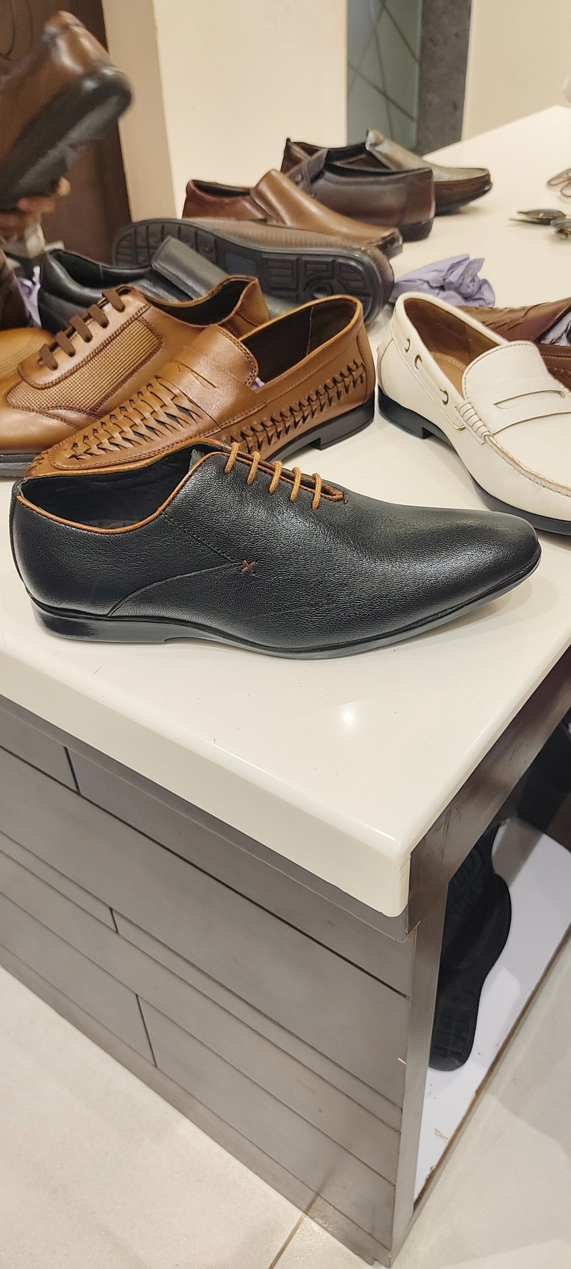 black leather dress shoes on white floor tiles