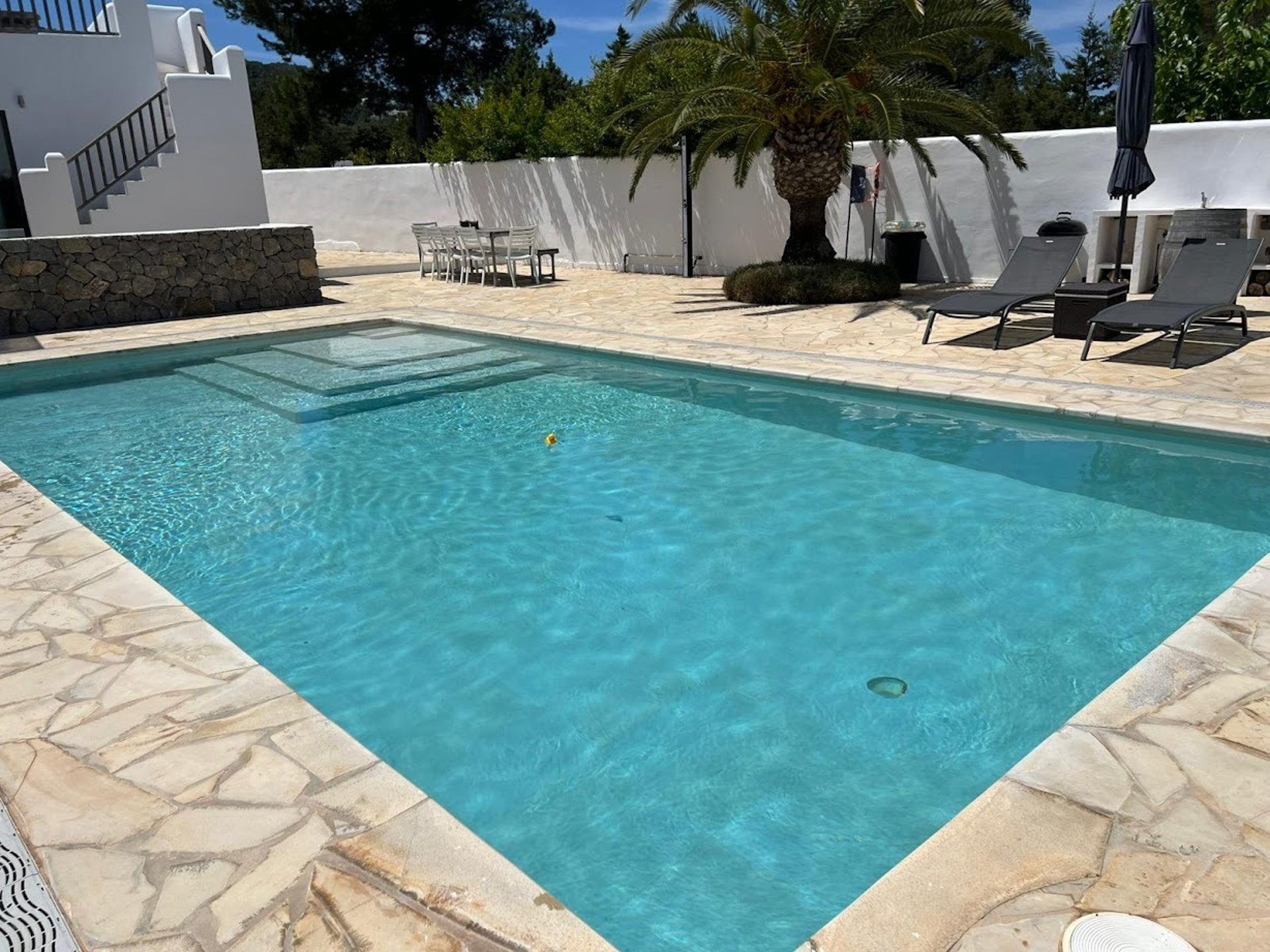 black metal chair beside white concrete wall