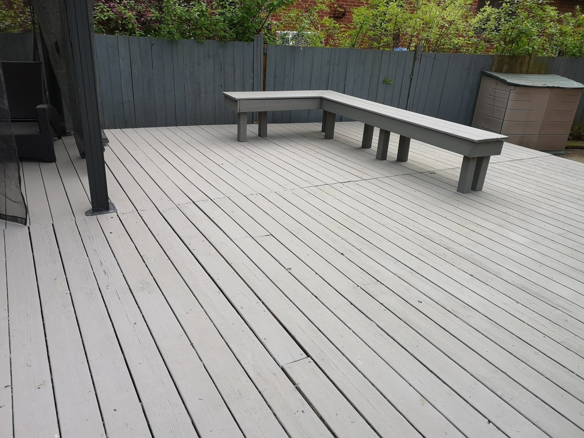 A backyard with a deck and a fence